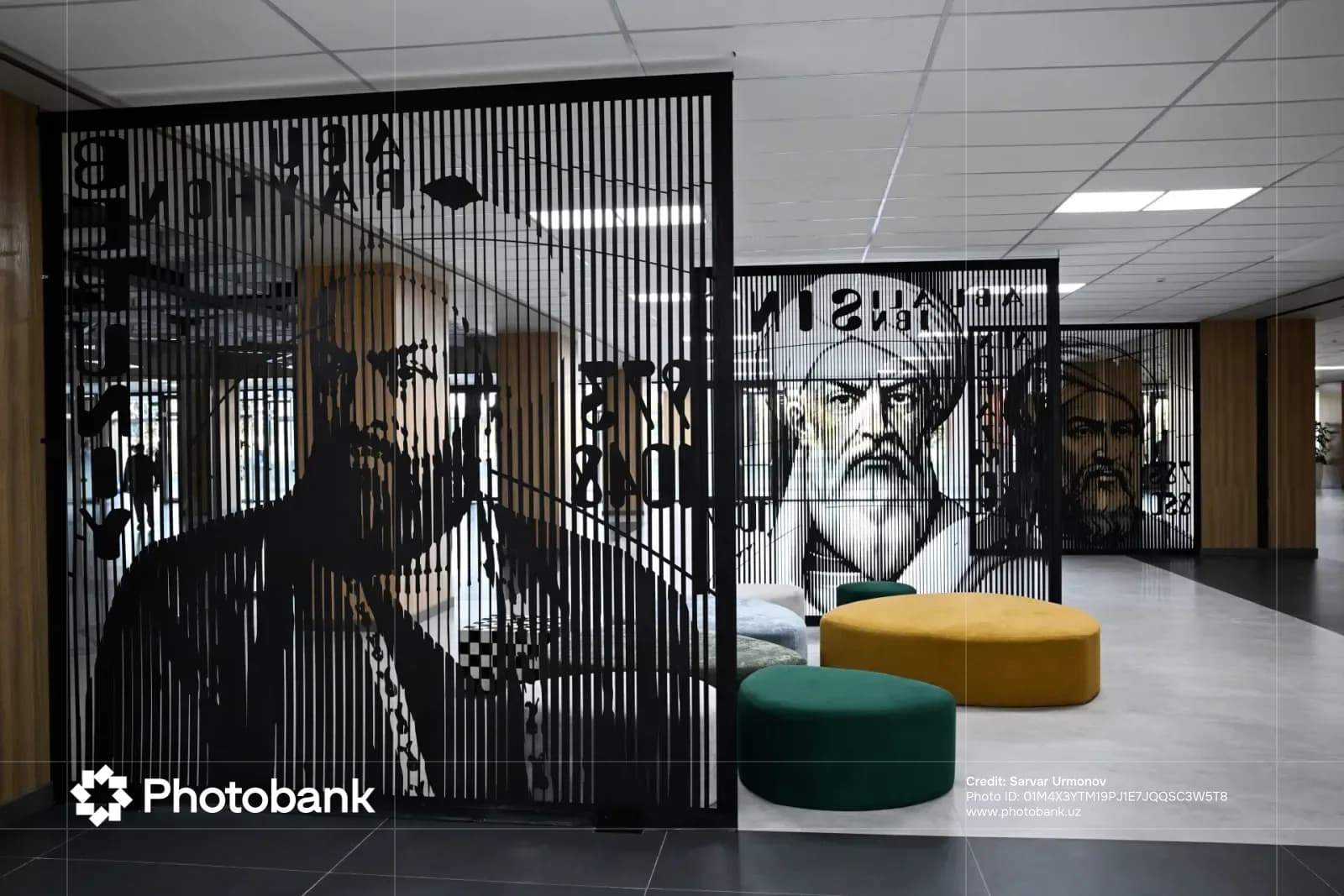 Interior view of an office space featuring decorative dividers with portraits