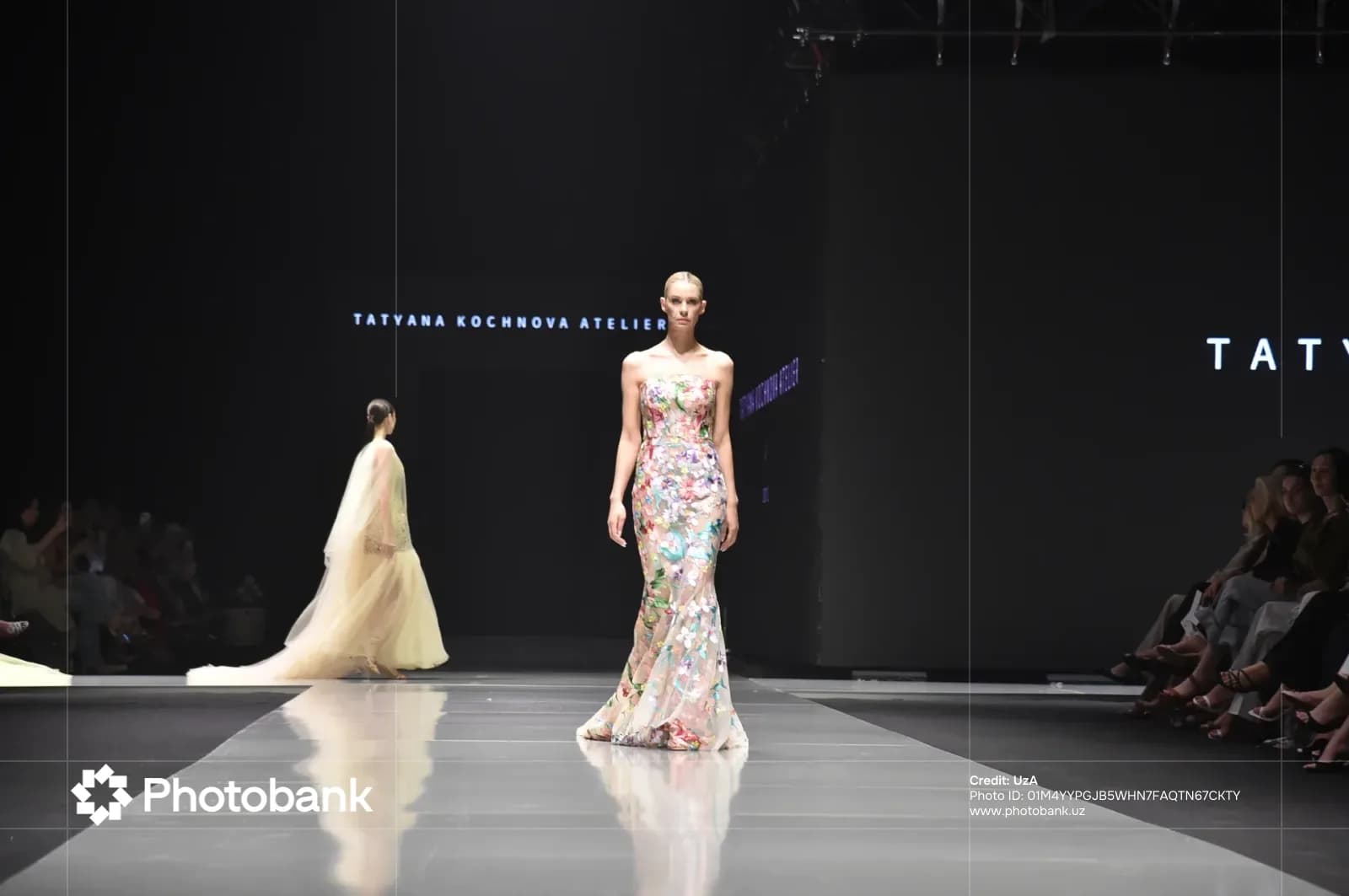 Models walk down a glossy runway at a fashion show