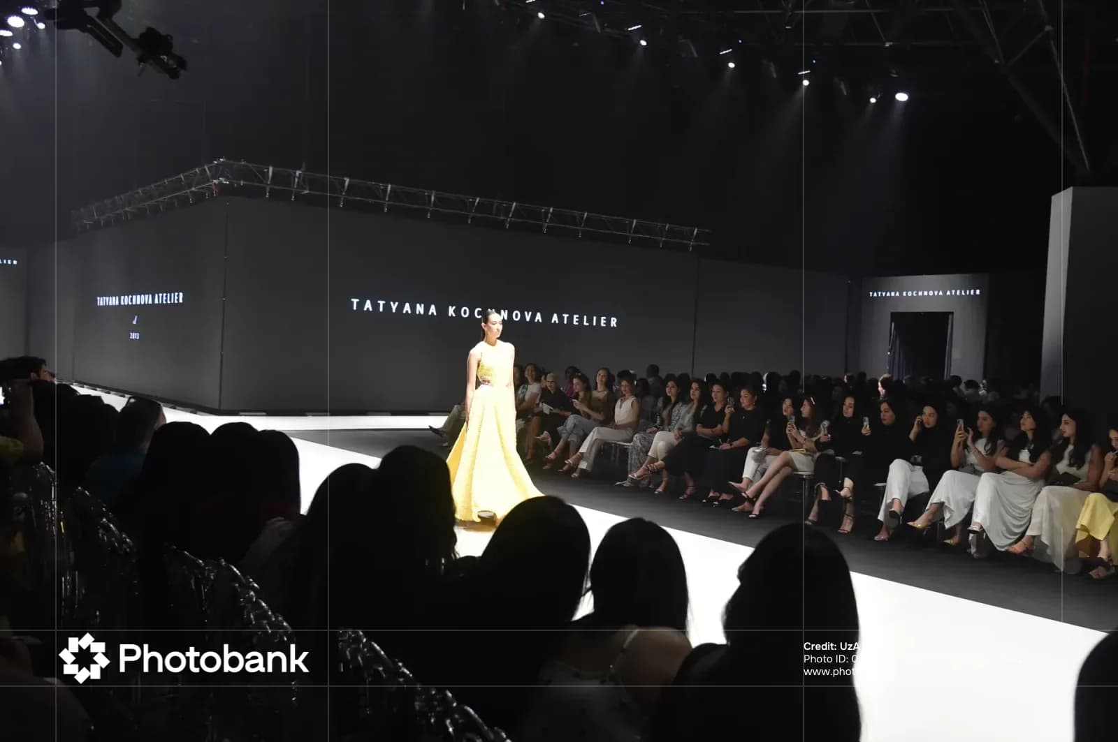 Model walking down runway during fashion show