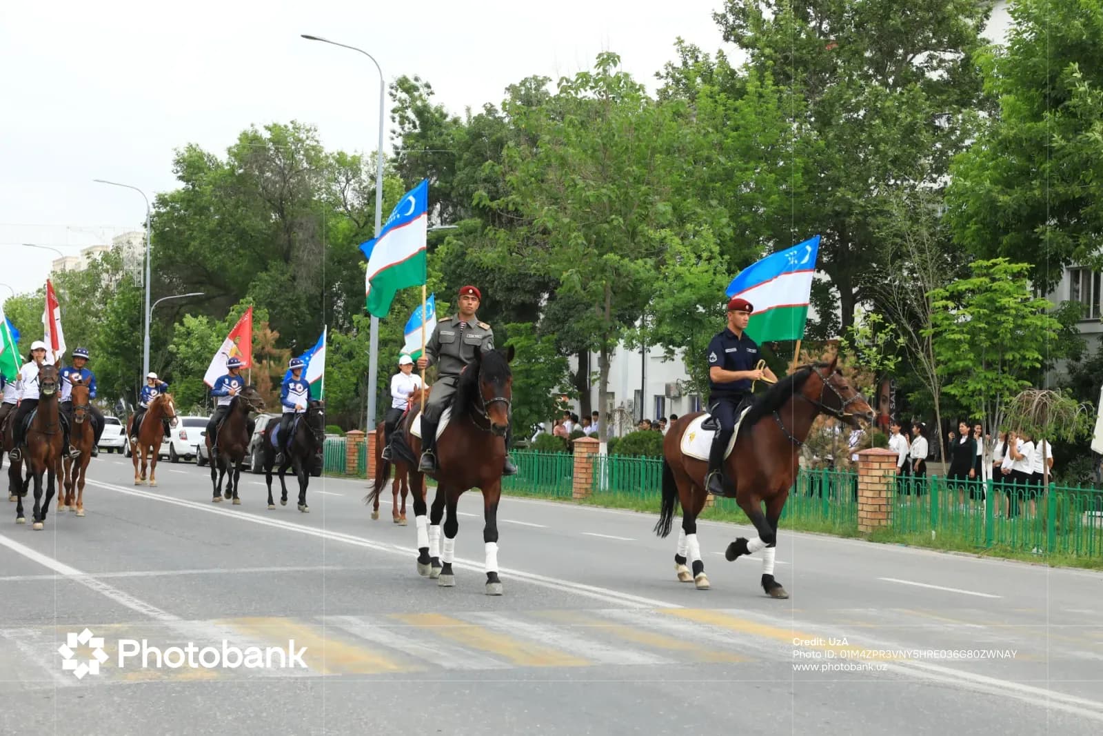 Люди на лошадях с флагами едут по городской улице