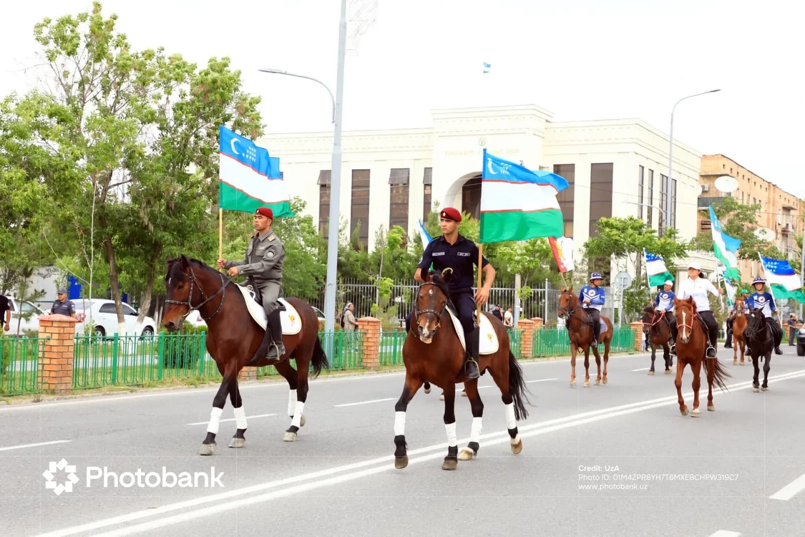 Всадники с государственными флагами на городской улице