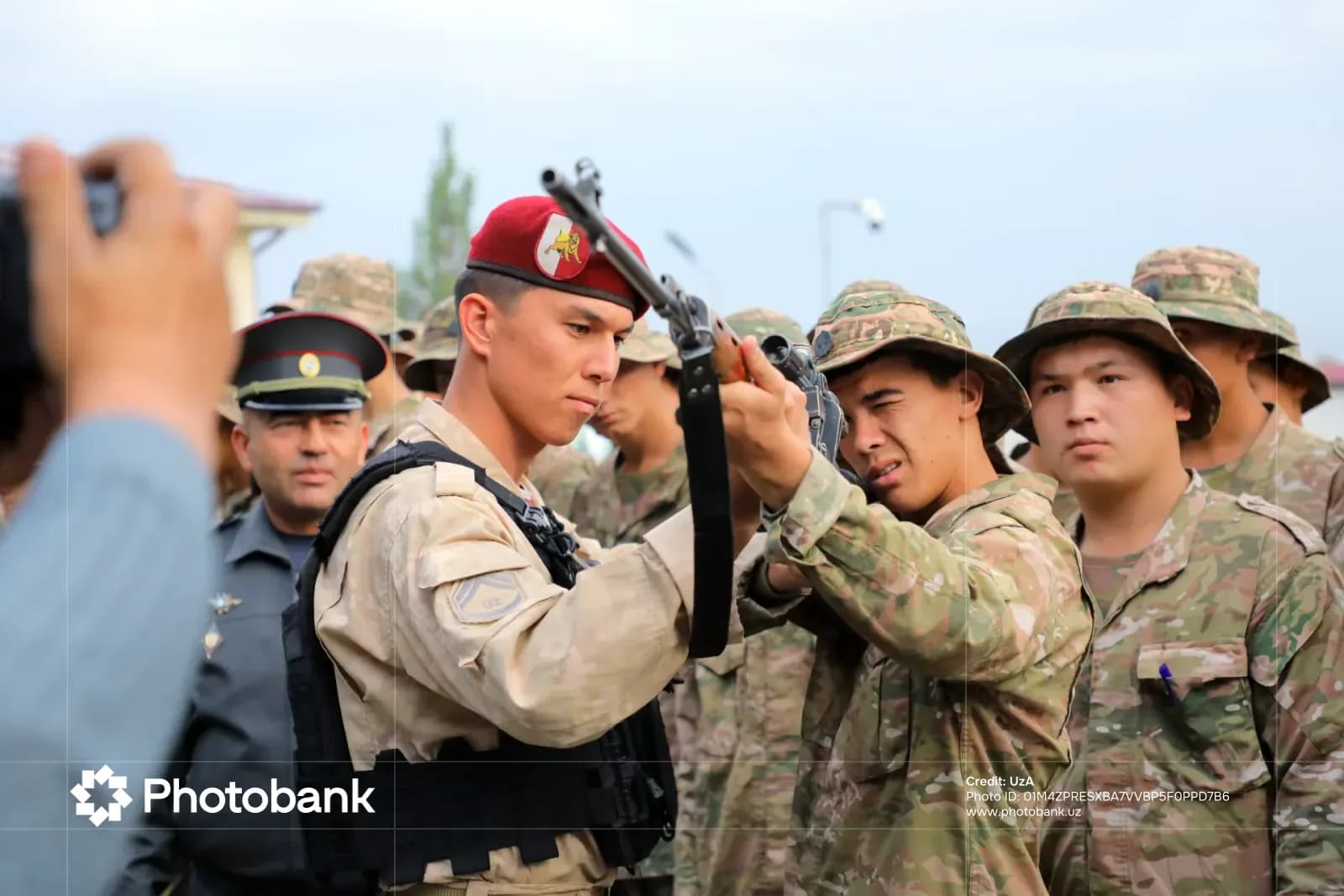 Люди в военной форме осматривают винтовку на улице