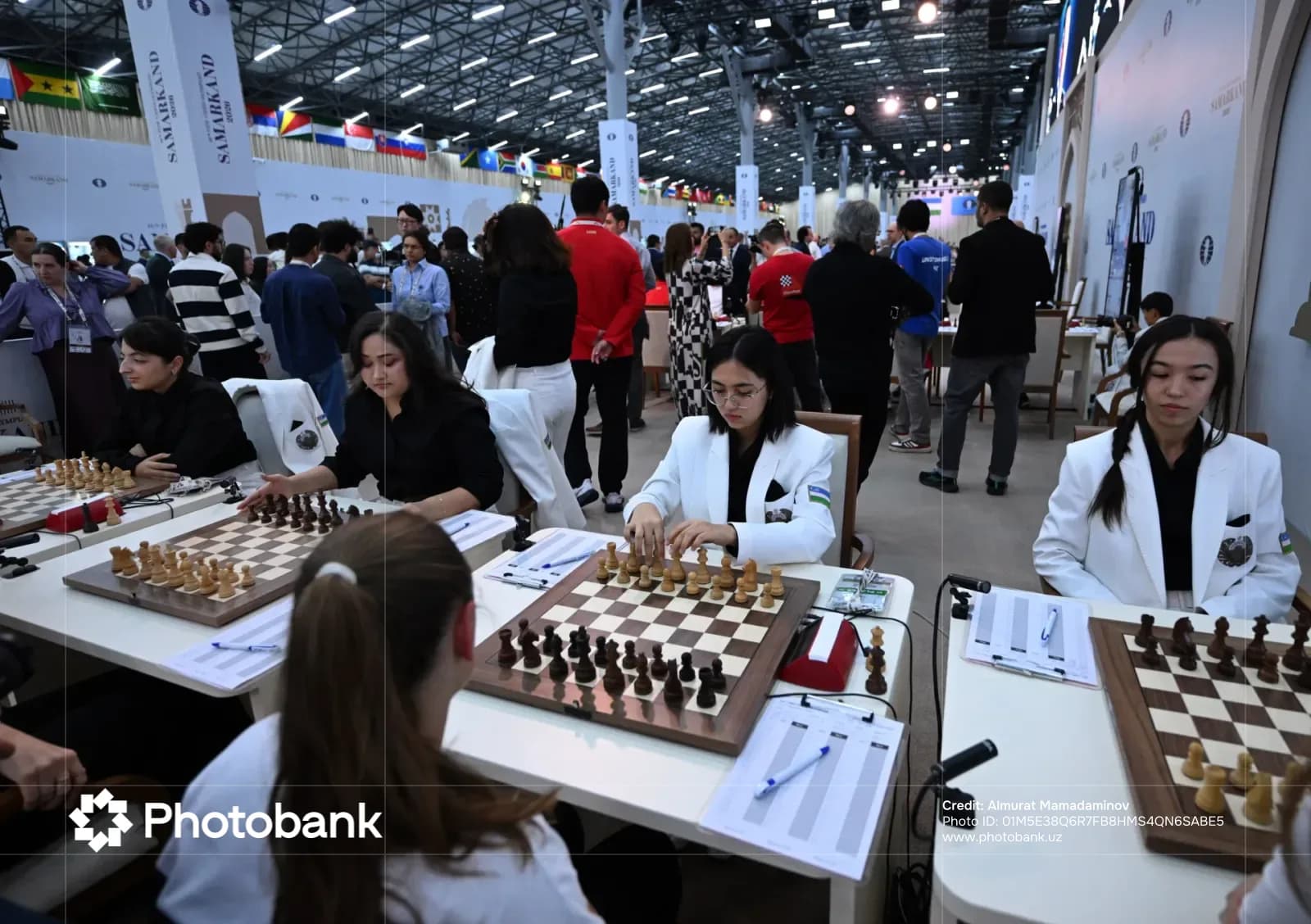 Competitors participate in an international chess tournament inside a large hall