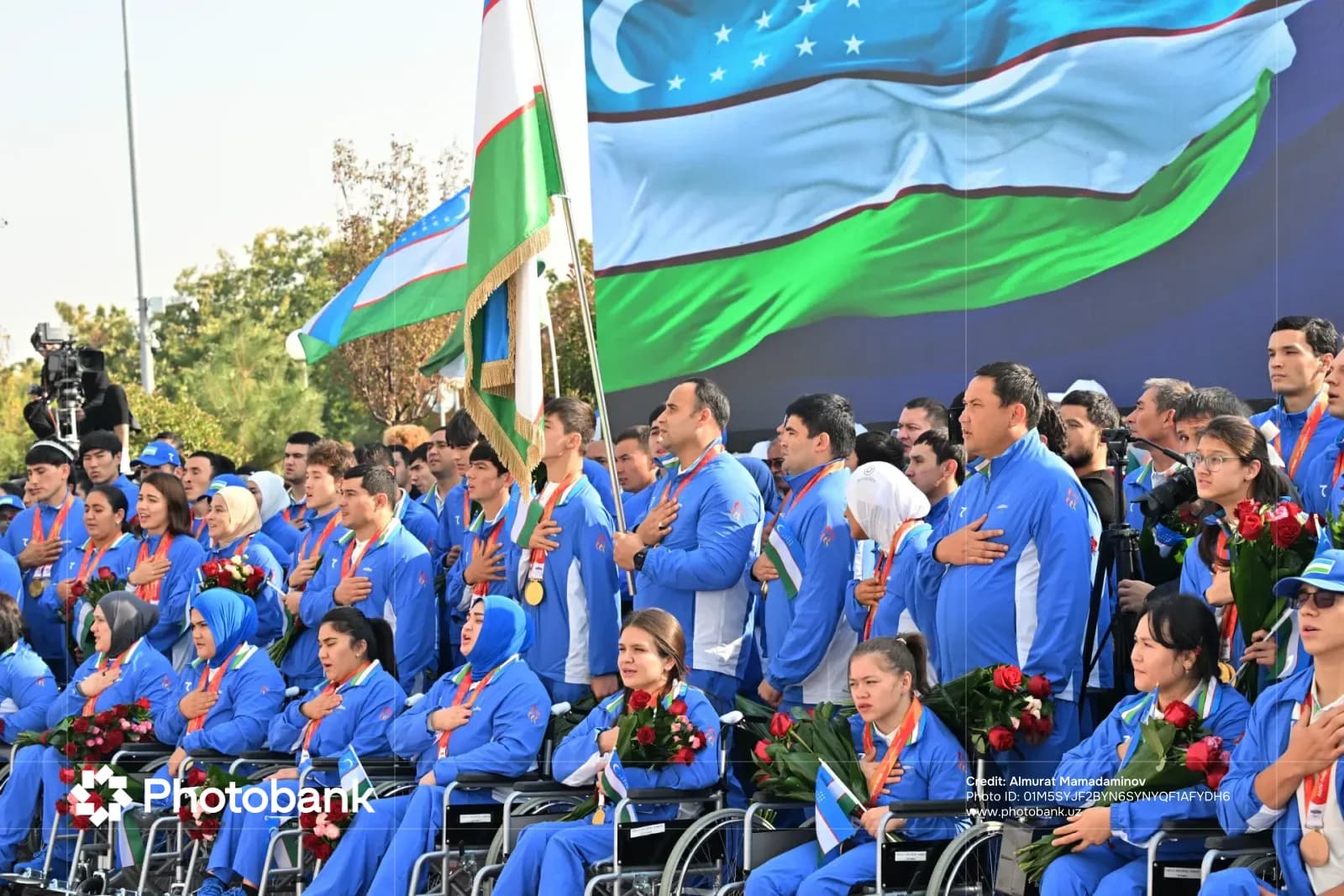 Athletes in matching blue sportswear stand together with hands placed over their chests