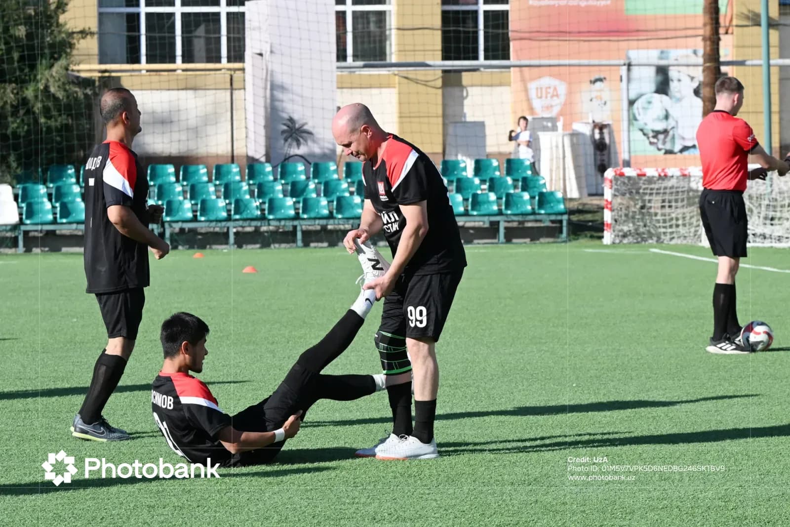 Спортсмены растягиваются на спортивной площадке