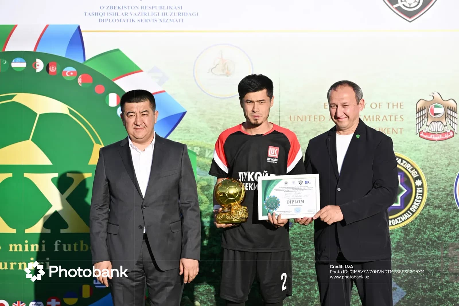 People posing with an award certificate and trophy