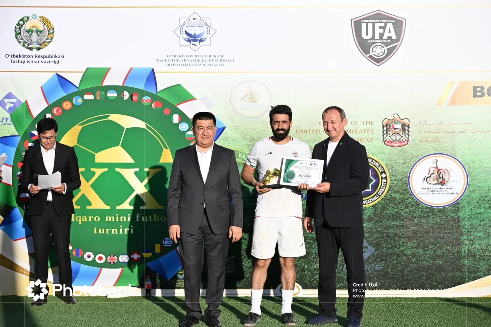 People at an awards presentation in front of a branded backdrop