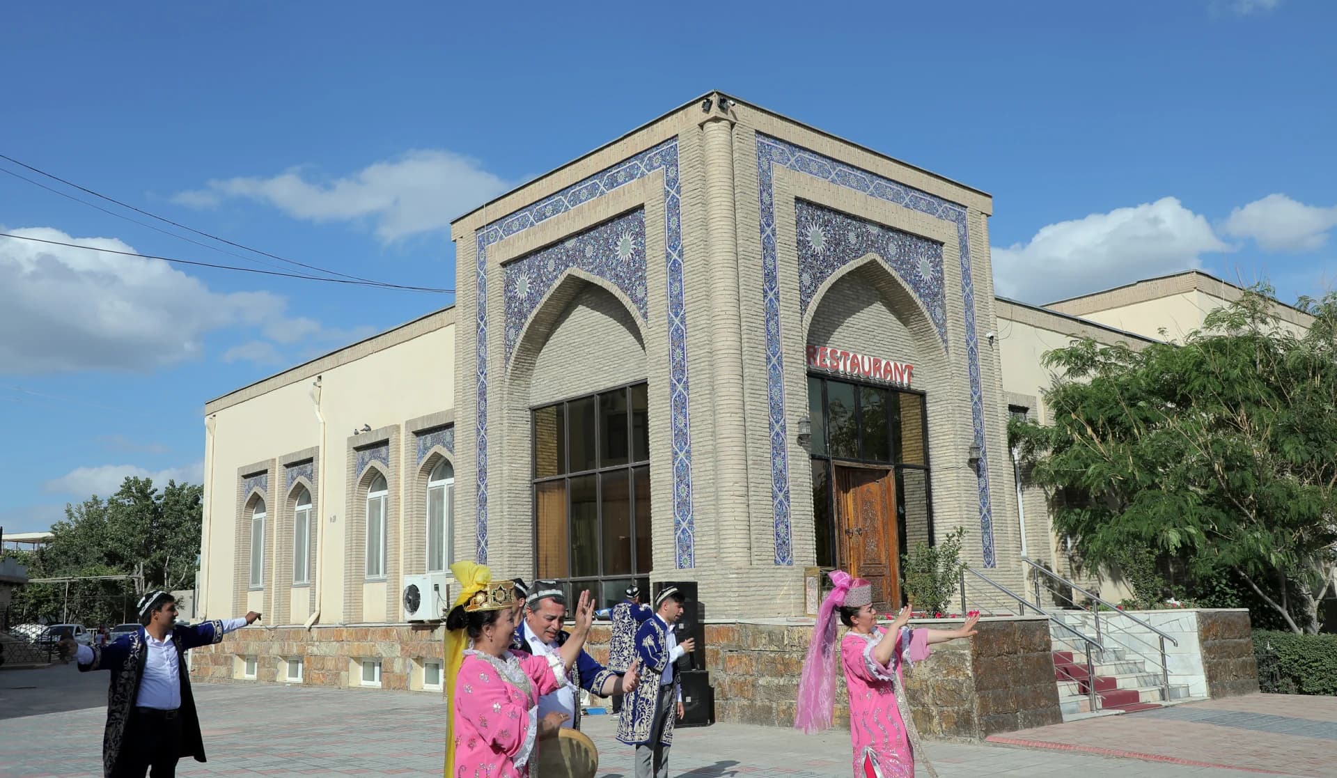 Исполнители, танцующие вне здания традиционного ресторана