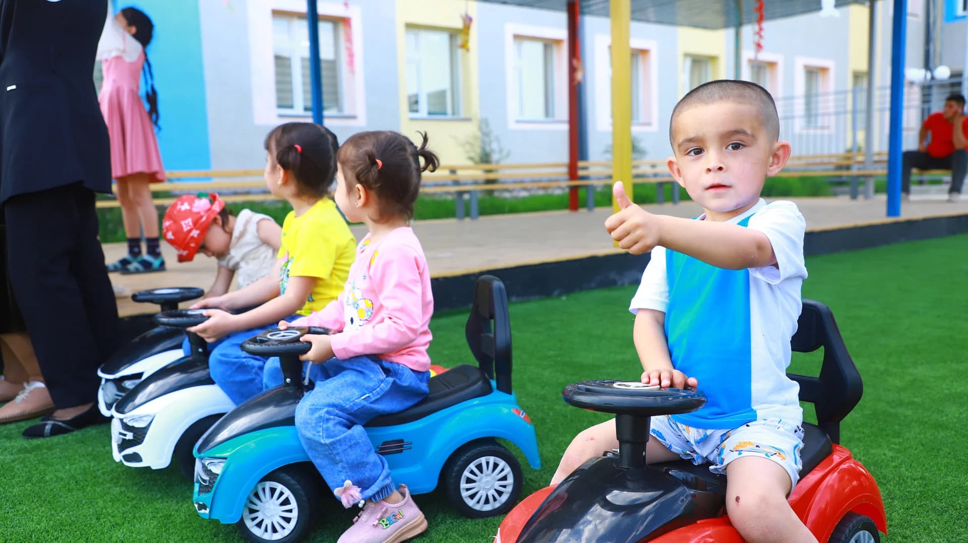 Дети катаются на игрушечных автомобилях на улице