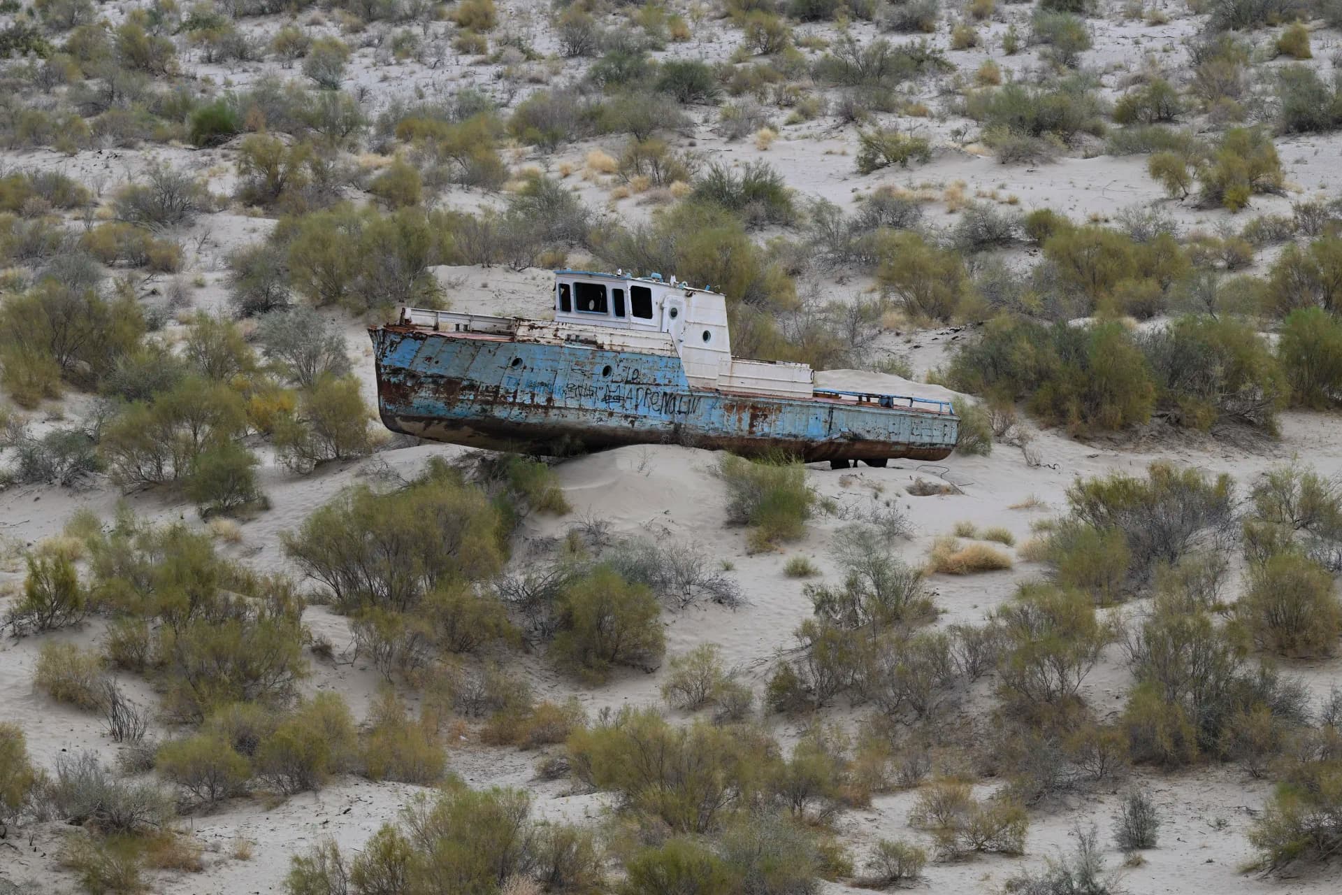Abandoned rusty ship stranded in a sandy desert landscape