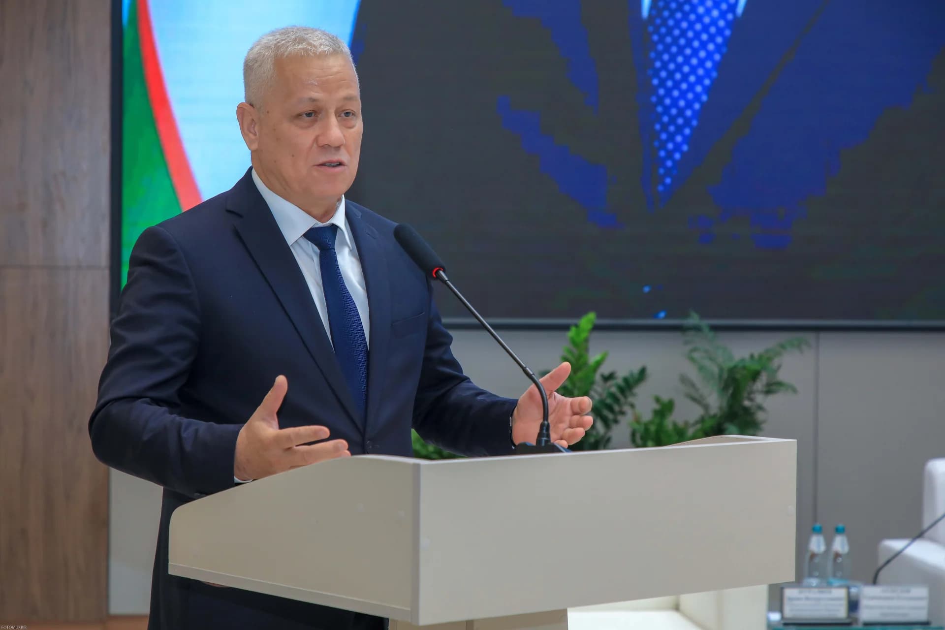 Мужчина, выступающий на трибуне
