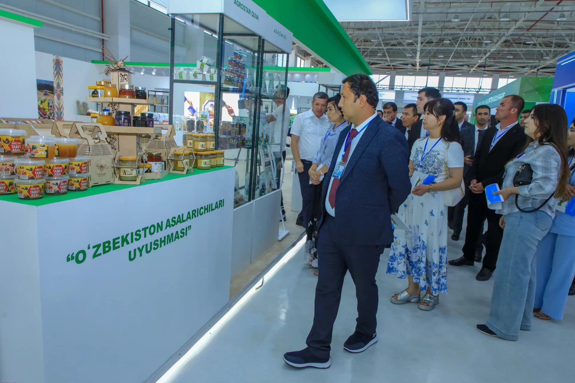 Люди, осматривающие медовую продукцию на выставке