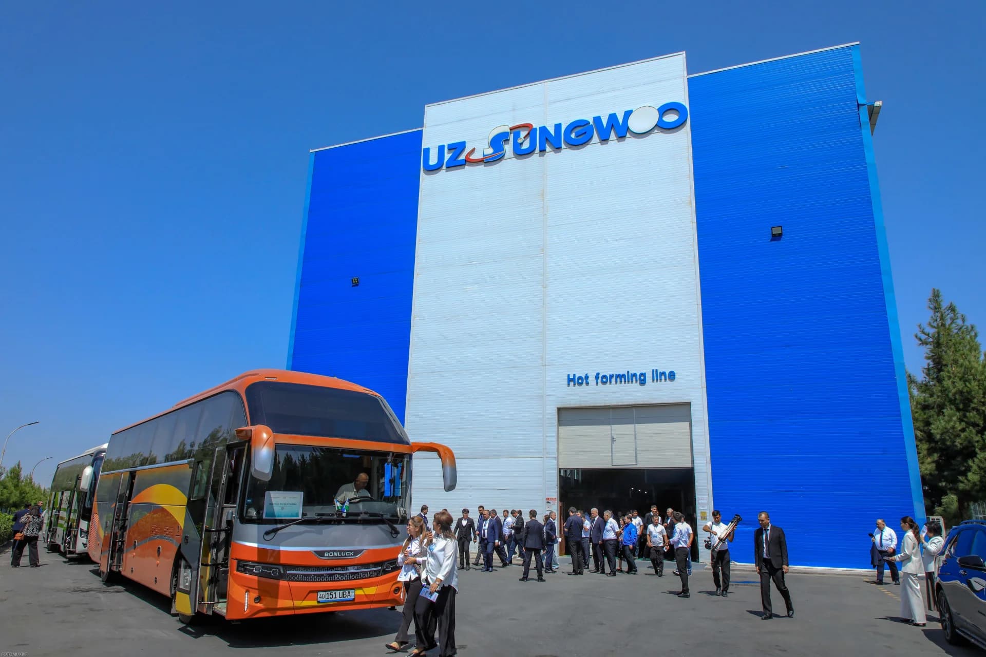 People gathered outside a building with buses parked