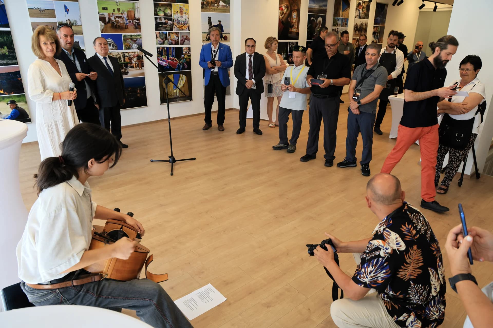 People gathered in an indoor space with photographs on the wall