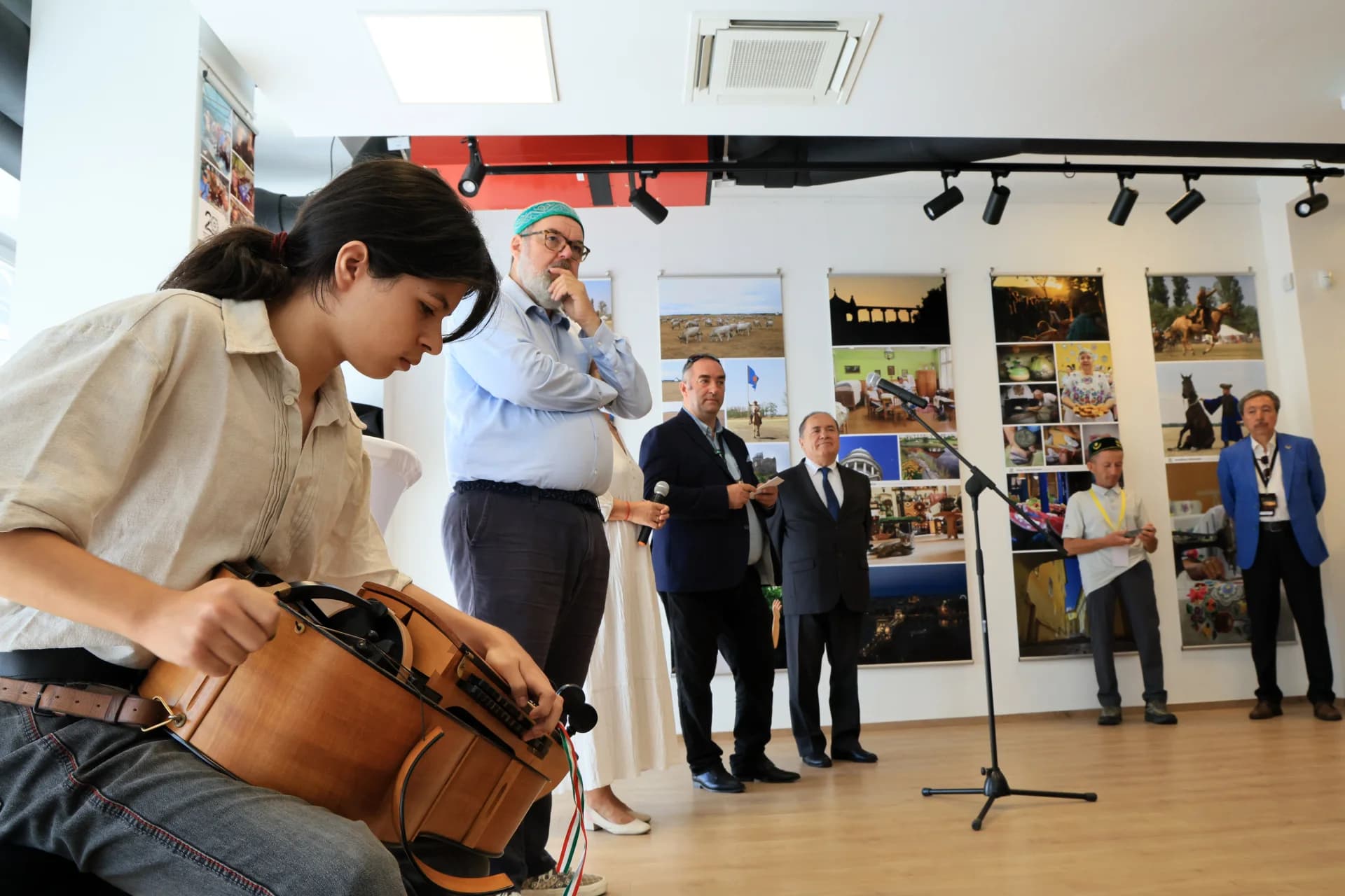 People gathered at a cultural exhibition with a musician playing a stringed instrument