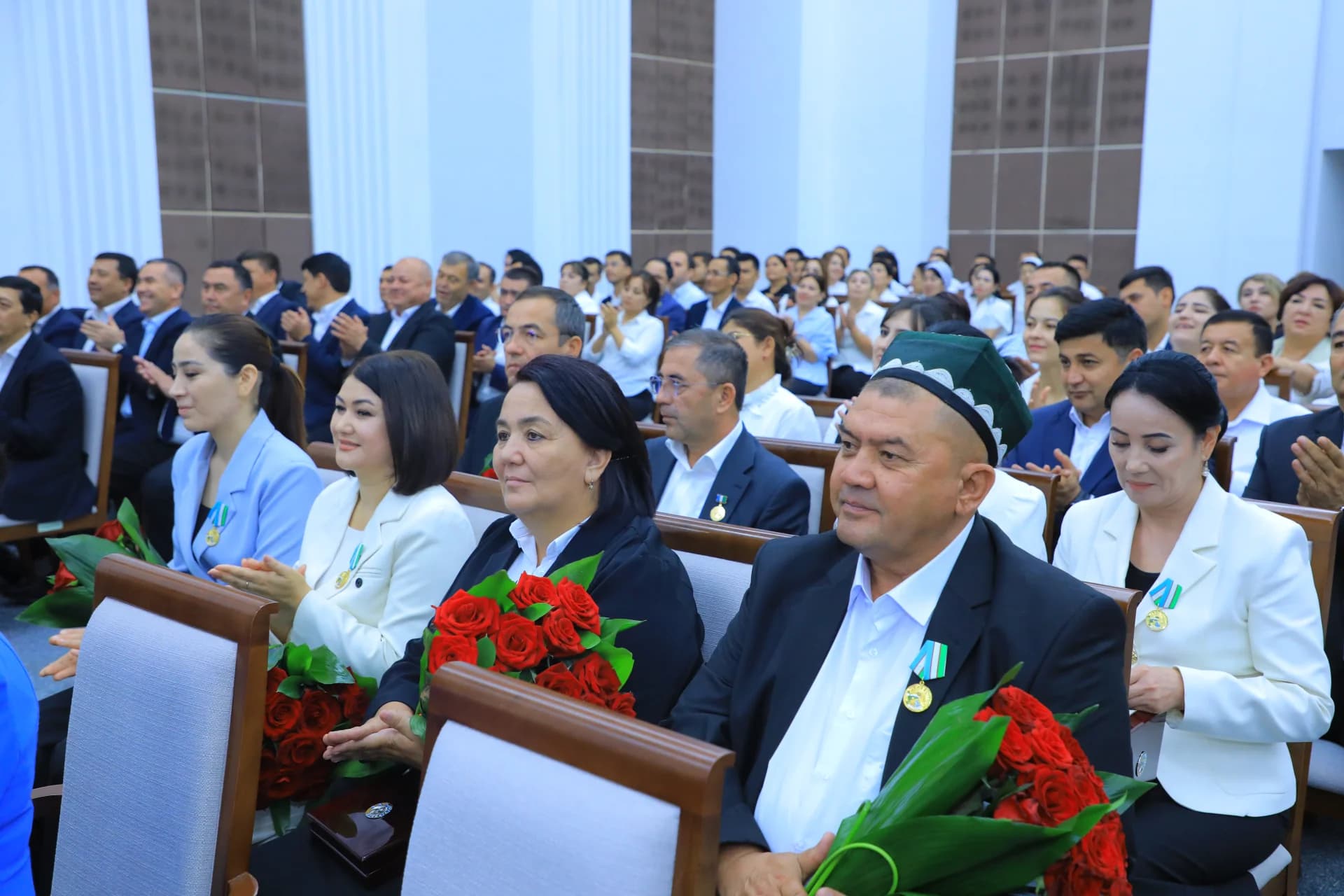 Люди, сидящие в аудитории и аплодирующие