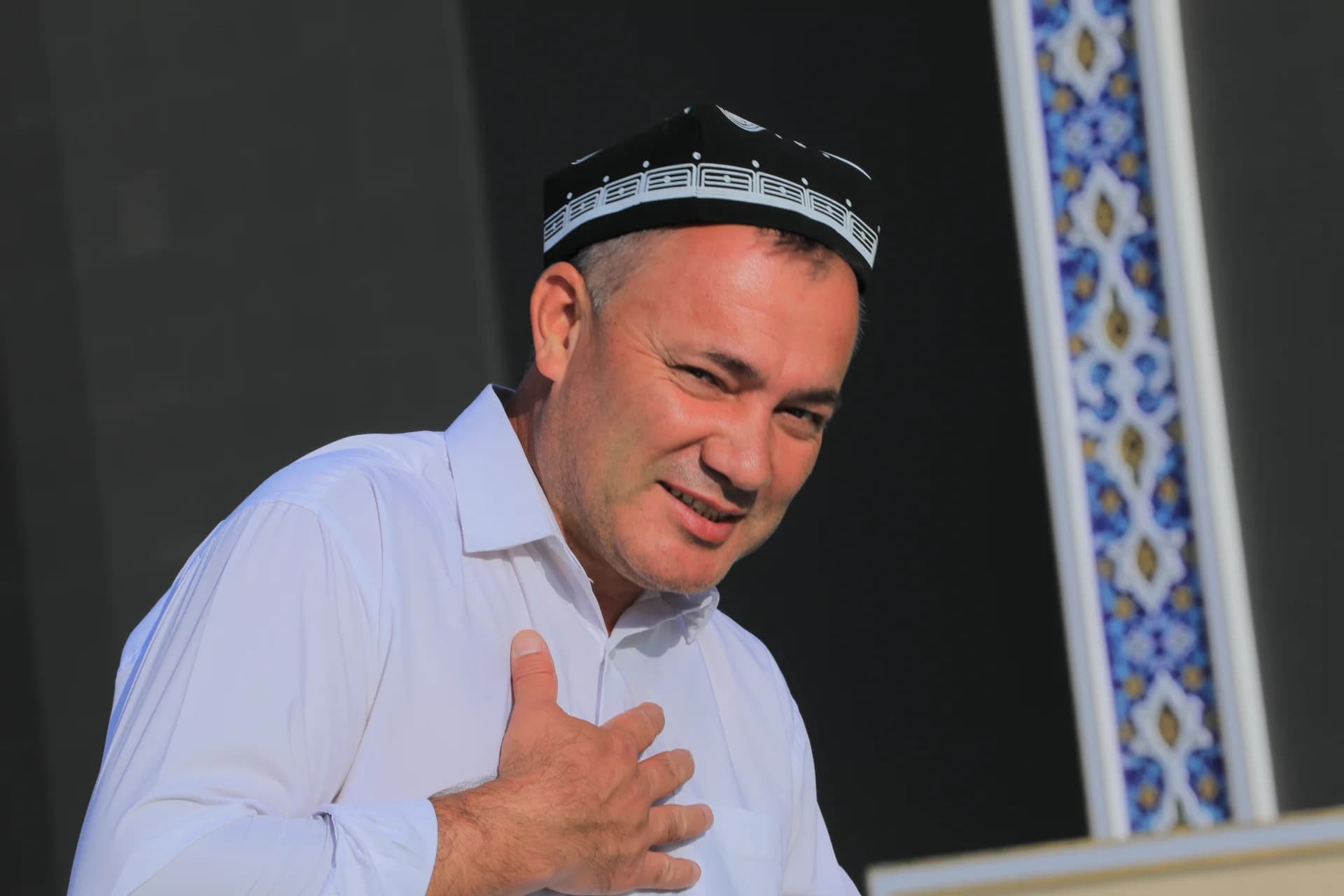 Портрет мужчины в традиционном тюбетейке и белой рубашке