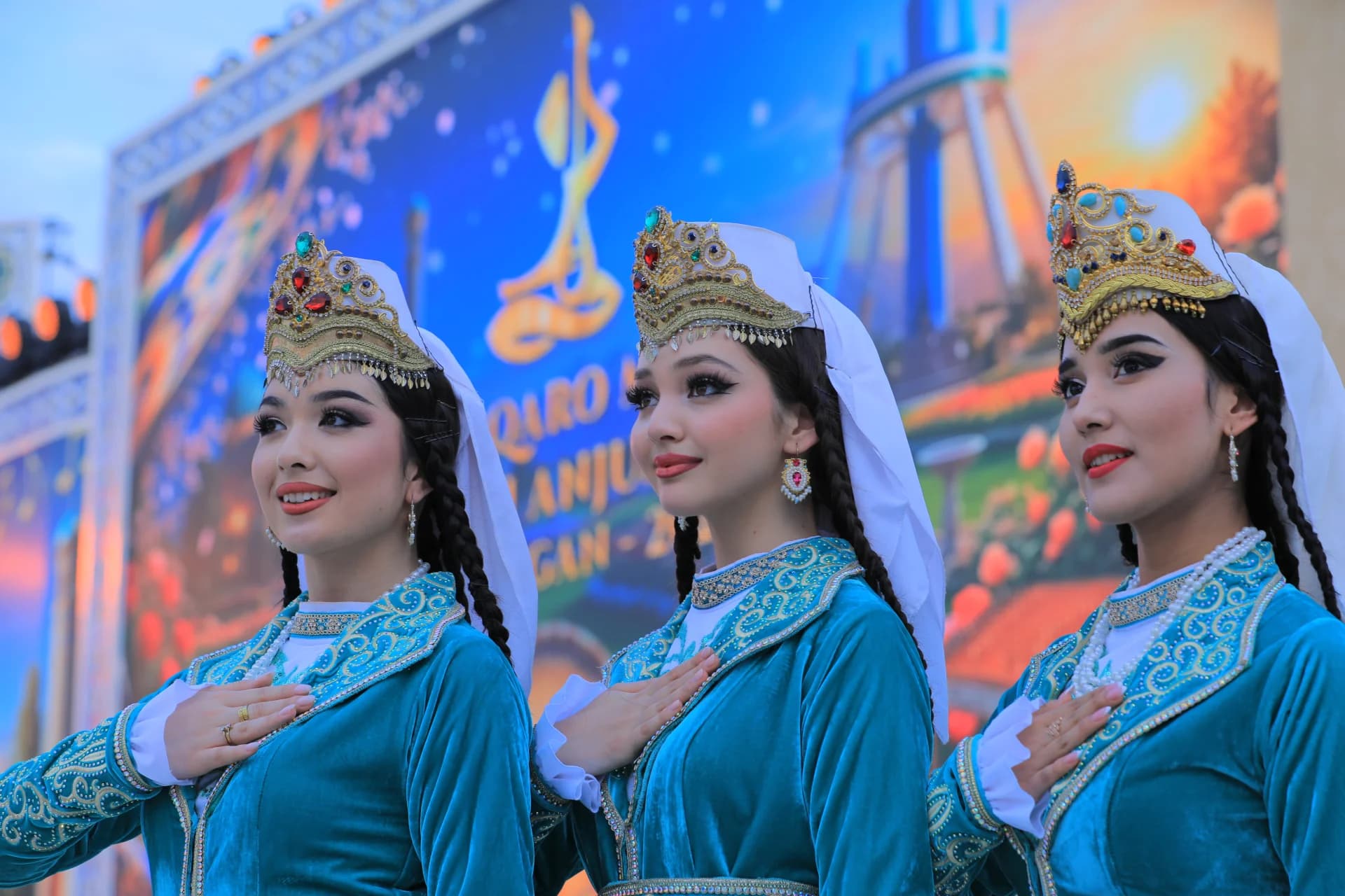 Три молодые женщины в традиционных костюмах позируют во время мероприятия