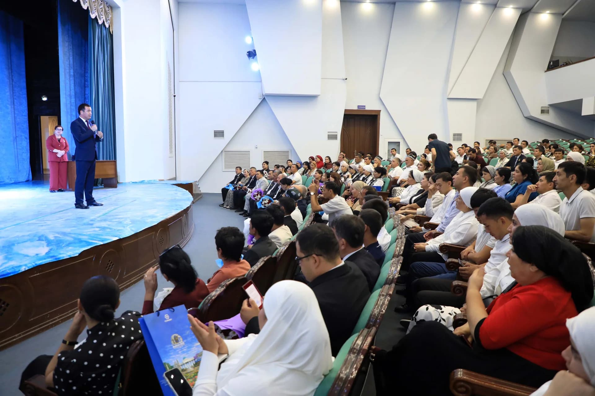 People gathered at a conference inside an auditorium