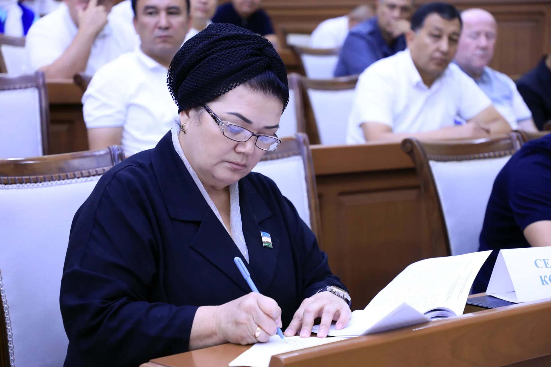 Person writing notes at a meeting