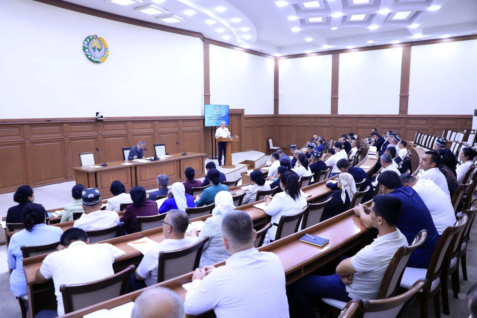 People attending a formal meeting in a large conference hall