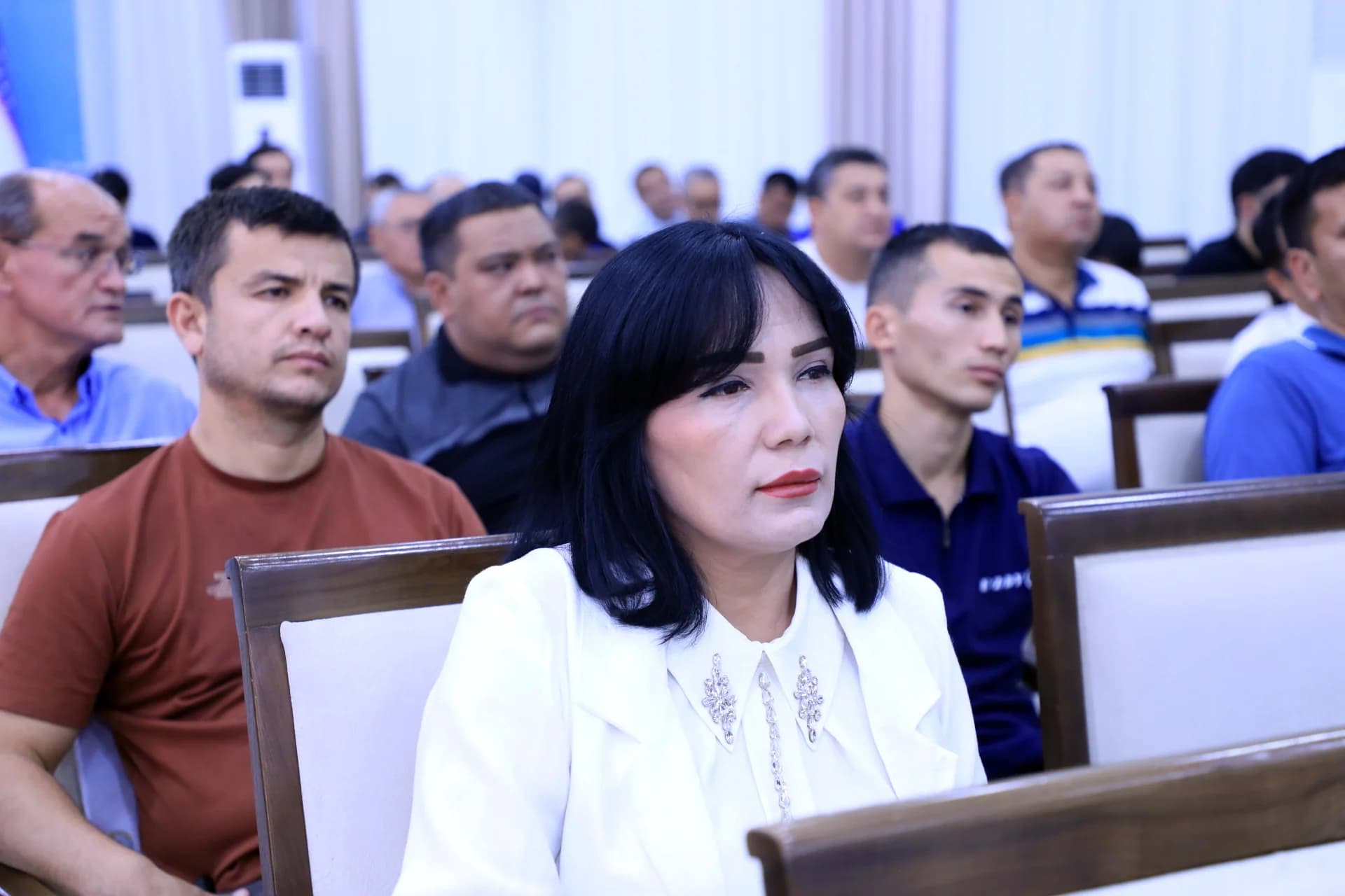 People seated together attending a meeting indoors
