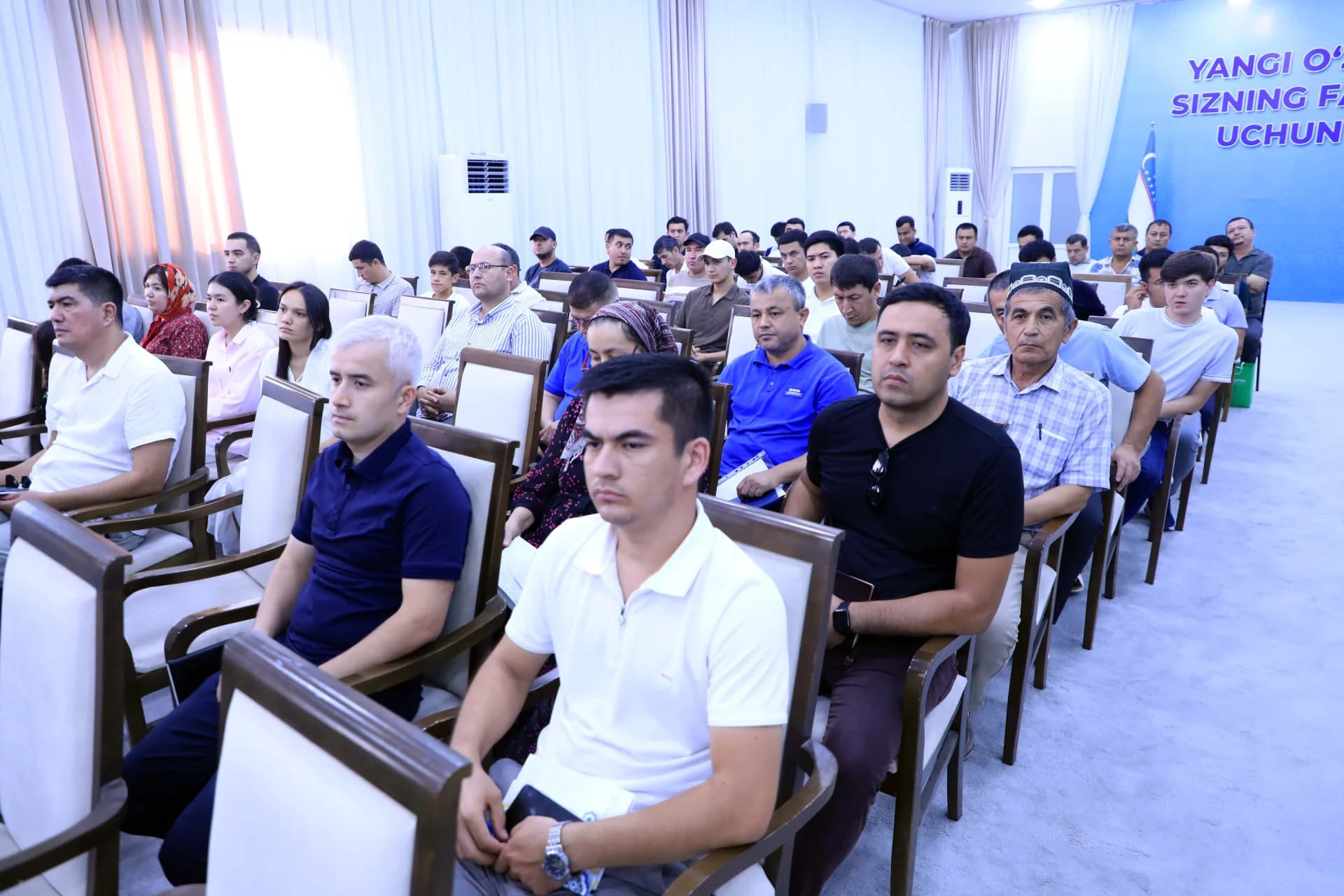 People seated in an auditorium listening attentively