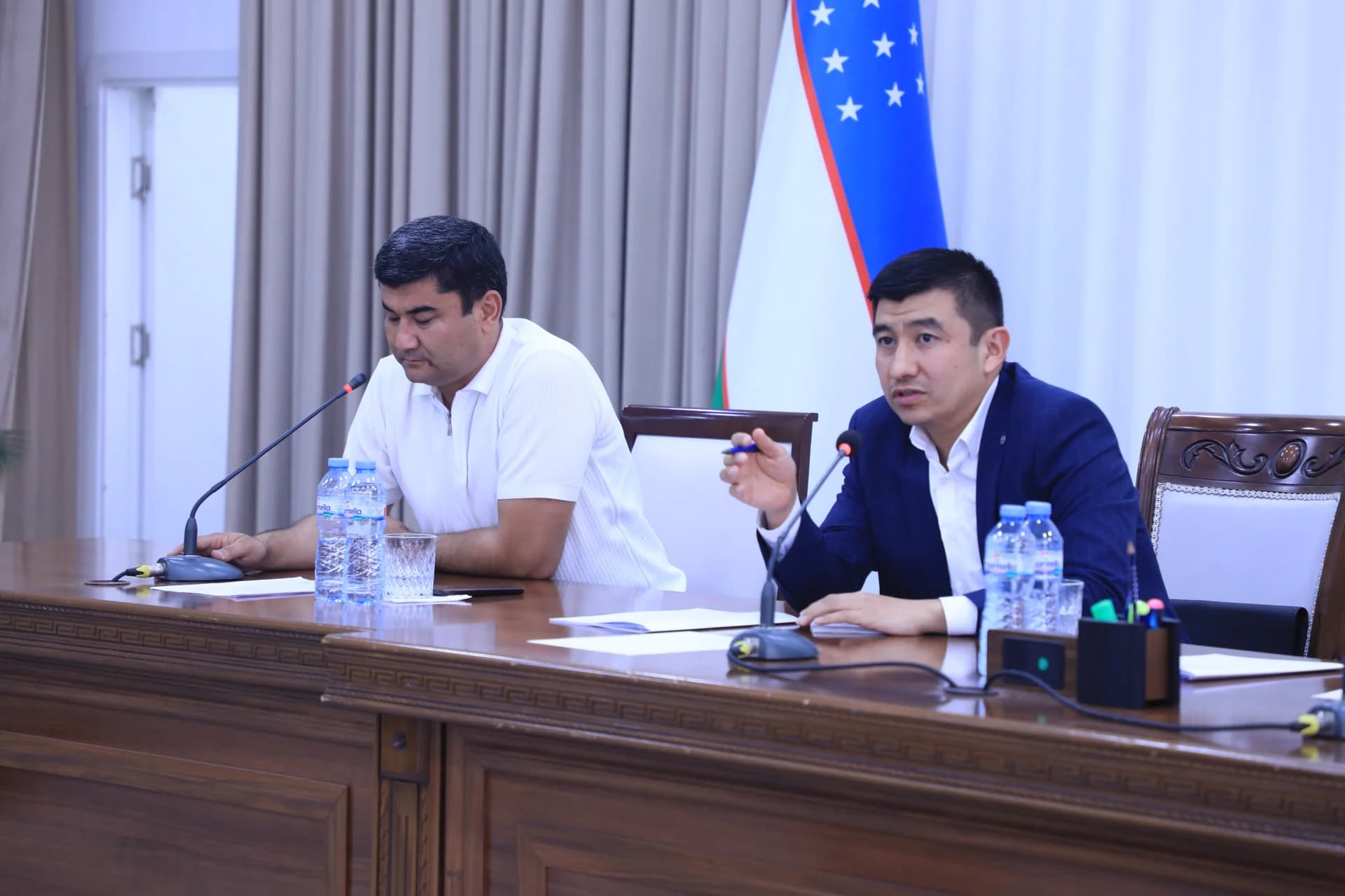 People participating in a meeting at a long wooden table