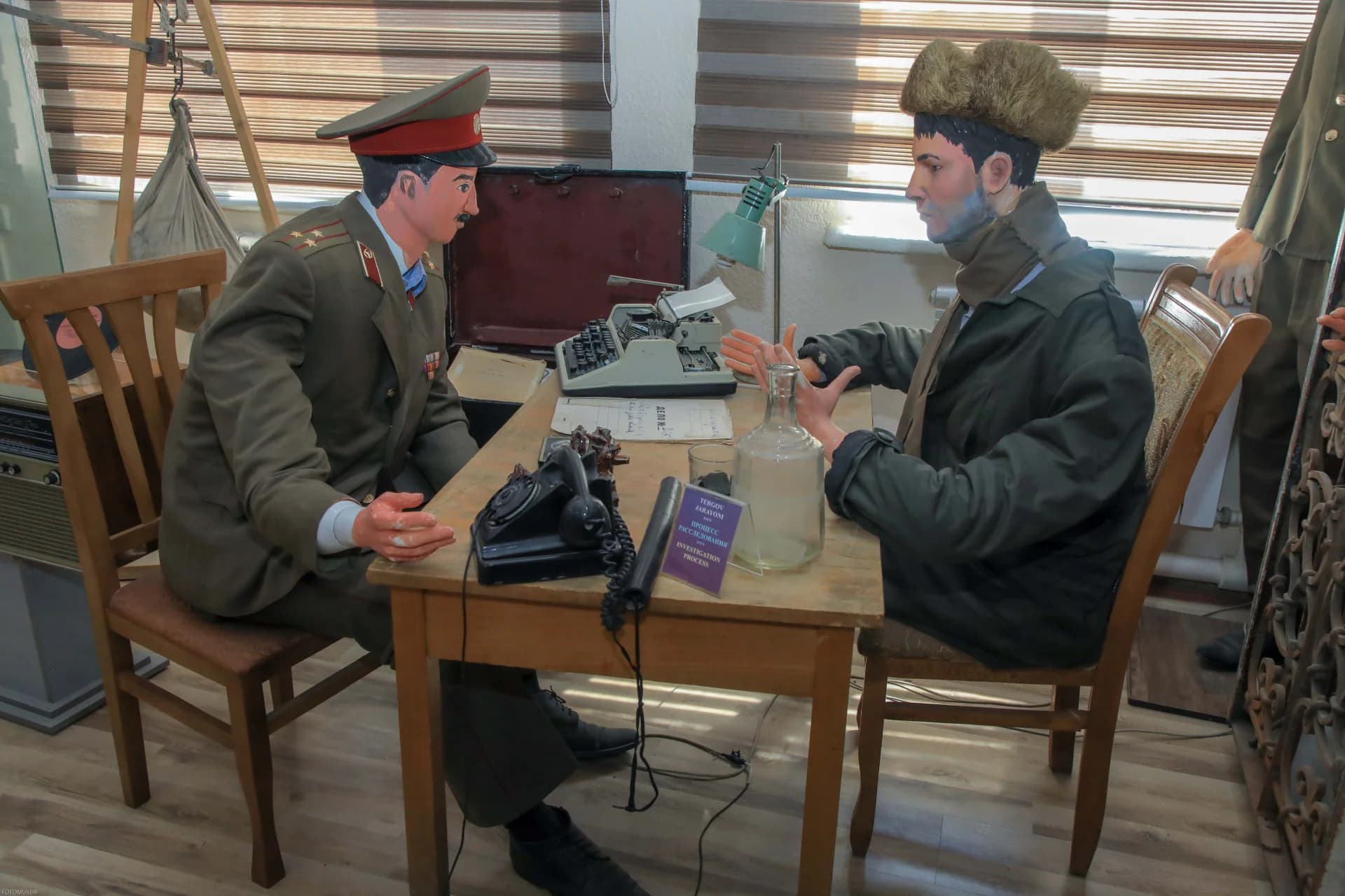 Historical display featuring mannequins in military and civilian attire seated at a desk