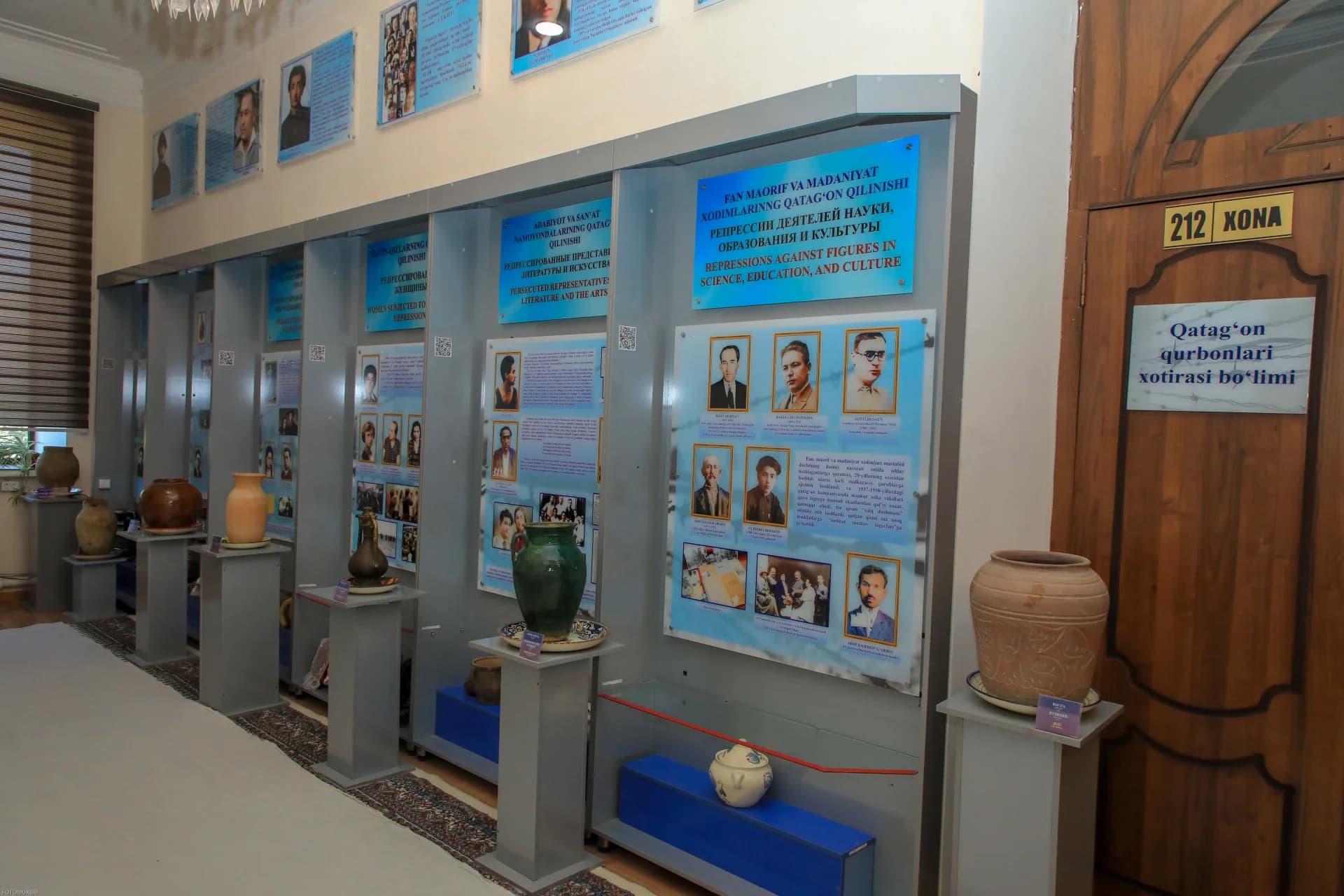 exhibition stands with informational panels and pottery vessels in a museum room