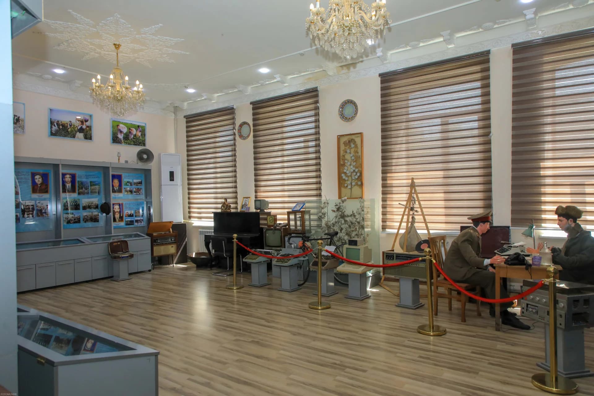 Interior view of a museum exhibition room with display cases and mannequins
