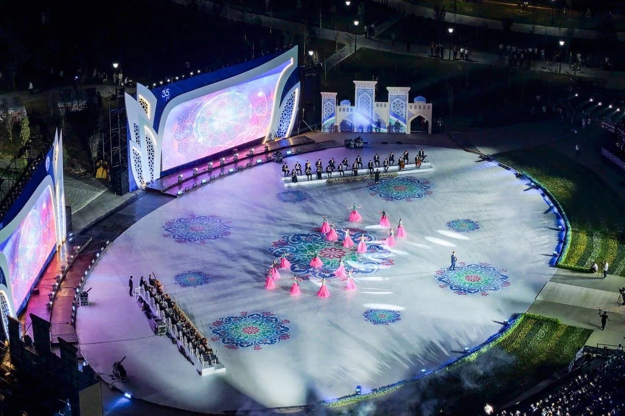 Outdoor cultural performance with dancers and musicians on stage at night