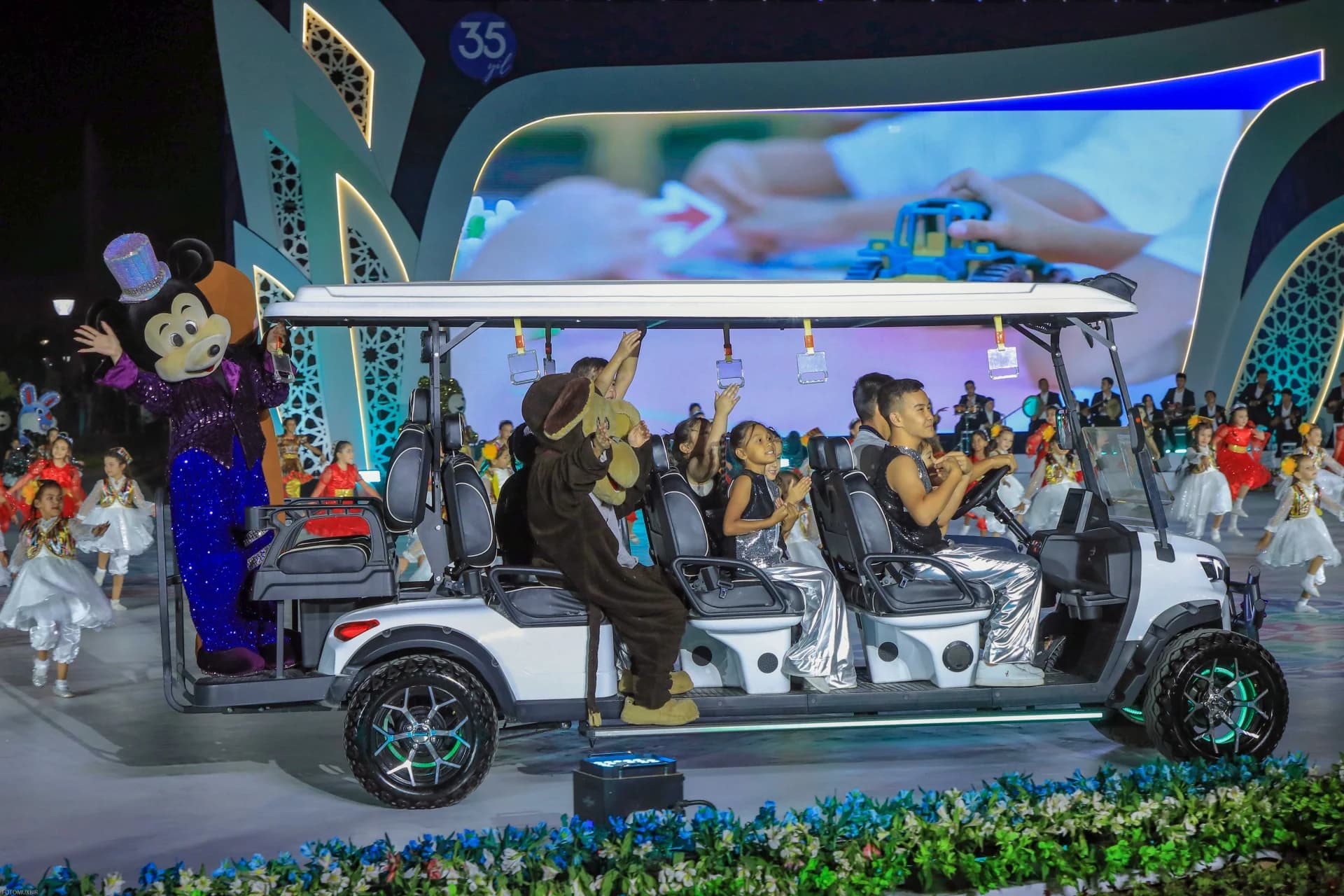 People riding in a decorated golf cart at an event