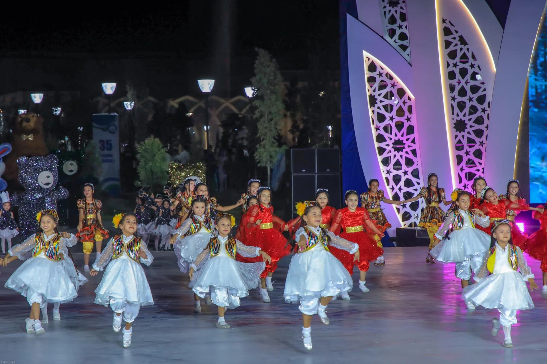 Children performing a dance on an outdoor stage