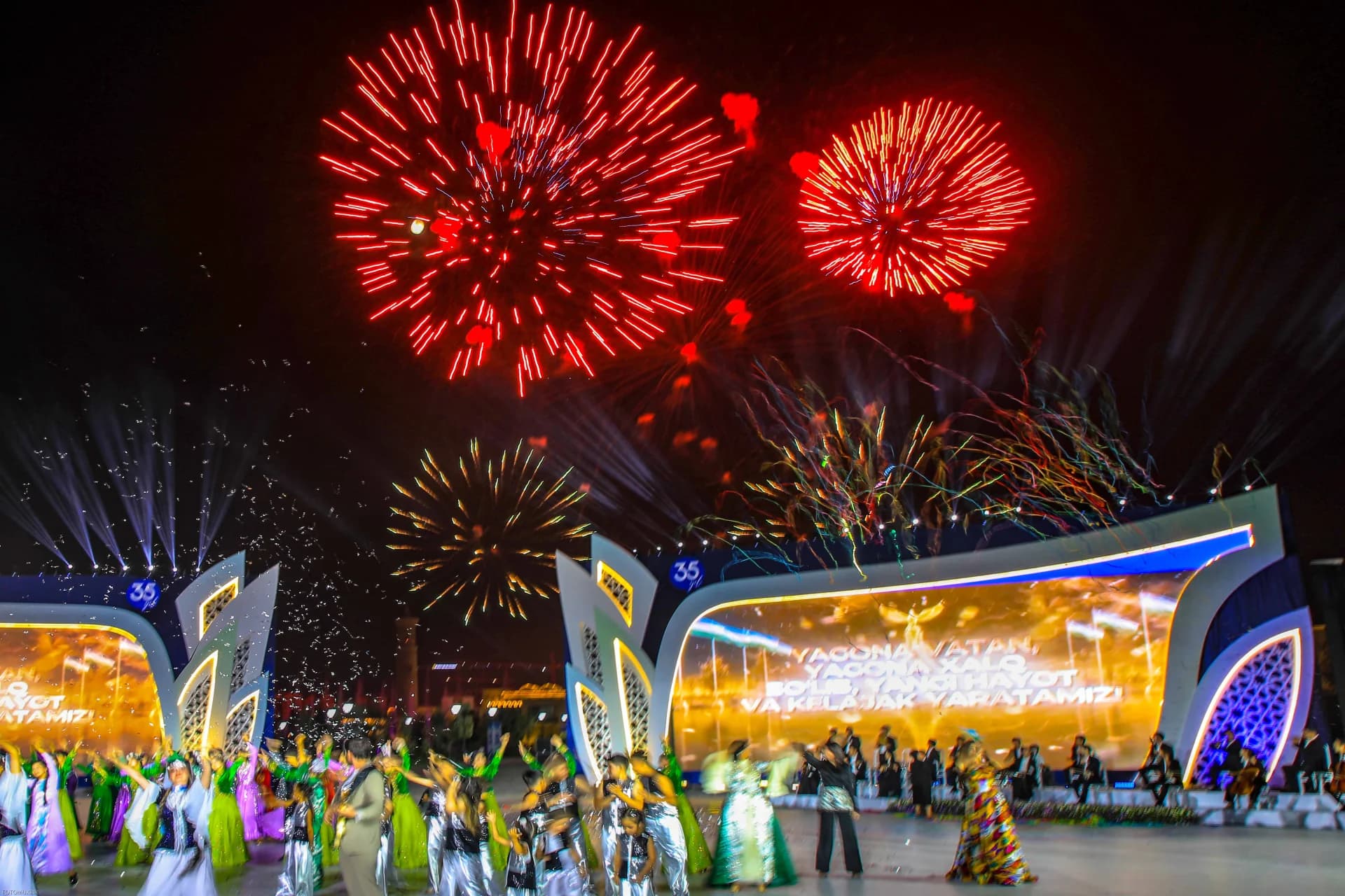 Festive fireworks illuminate the night sky over a performance event