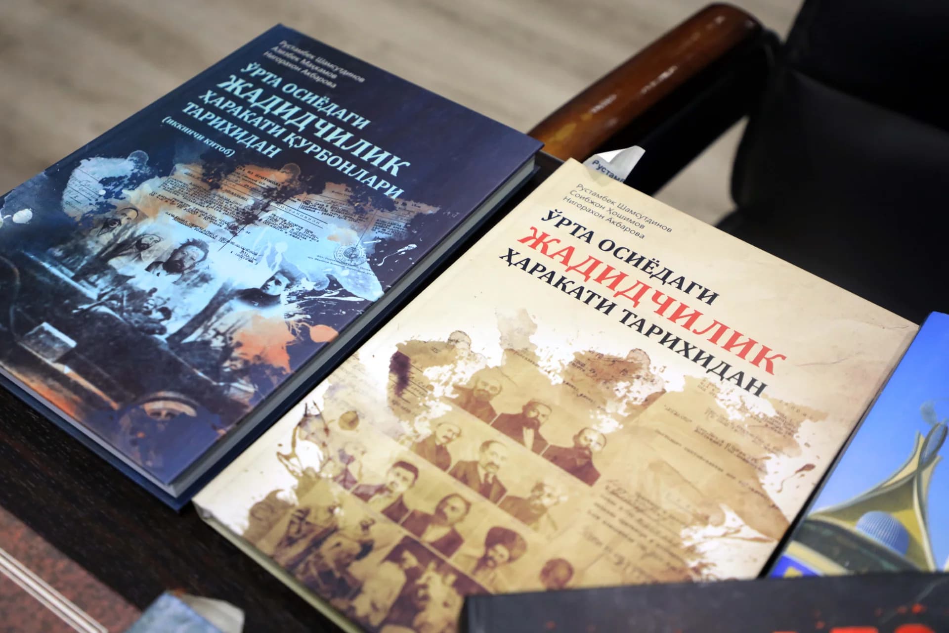 Books with historical covers placed on a dark surface