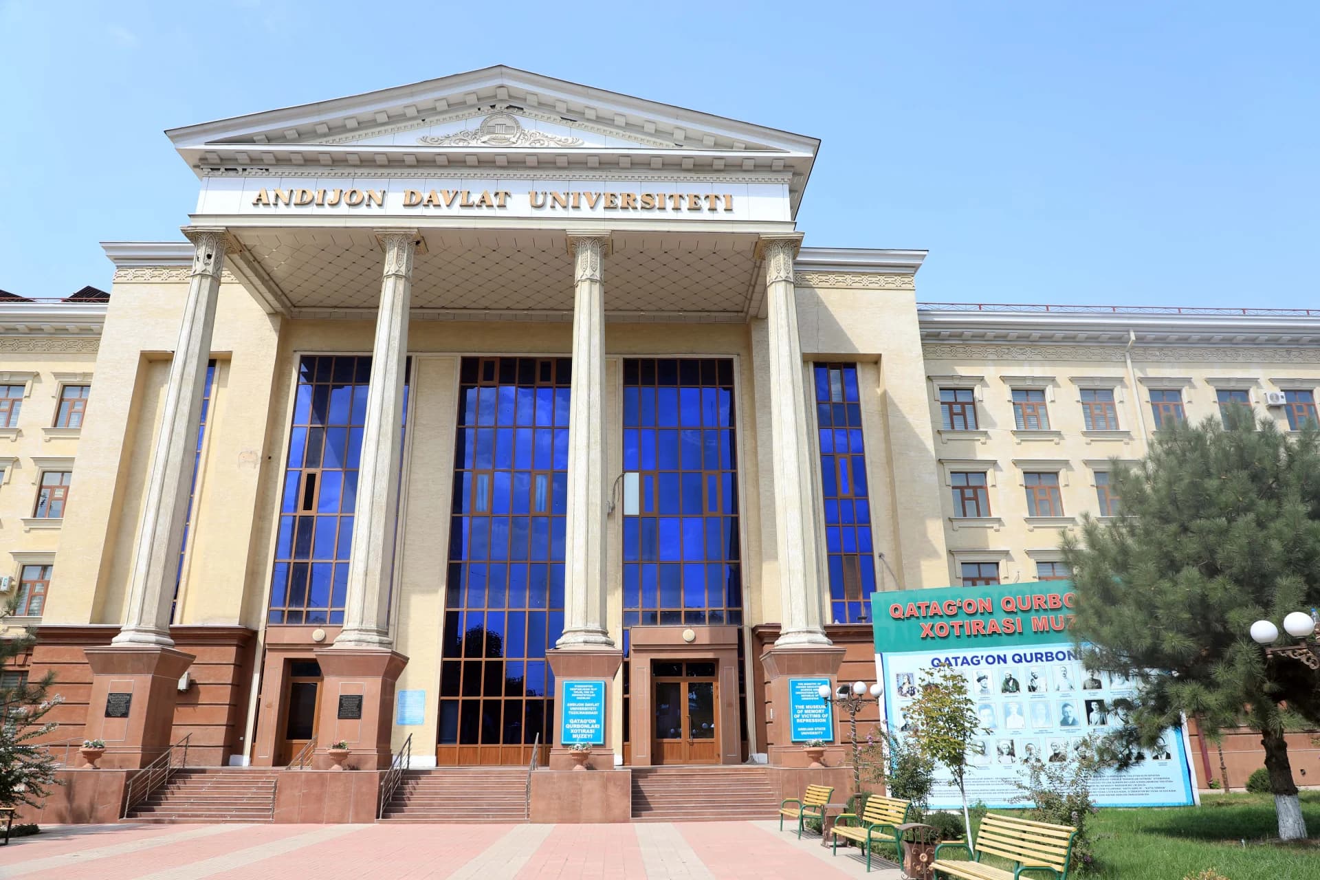 Facade of a large institutional building with columns and tall blue windows