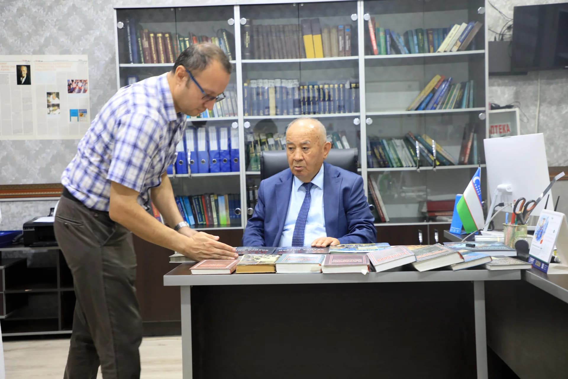People examining books in an office setting
