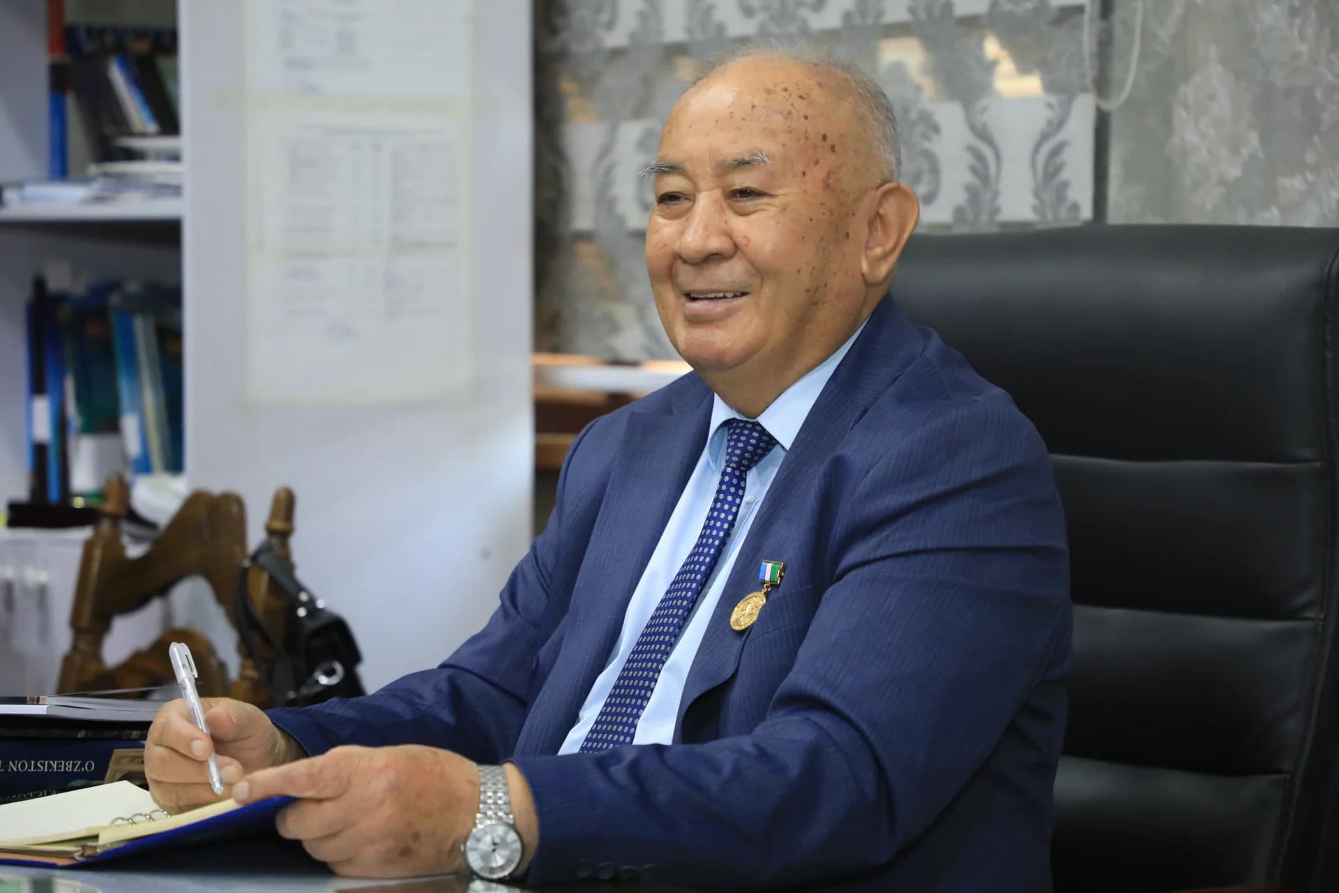 Portrait of an elderly man writing in an office