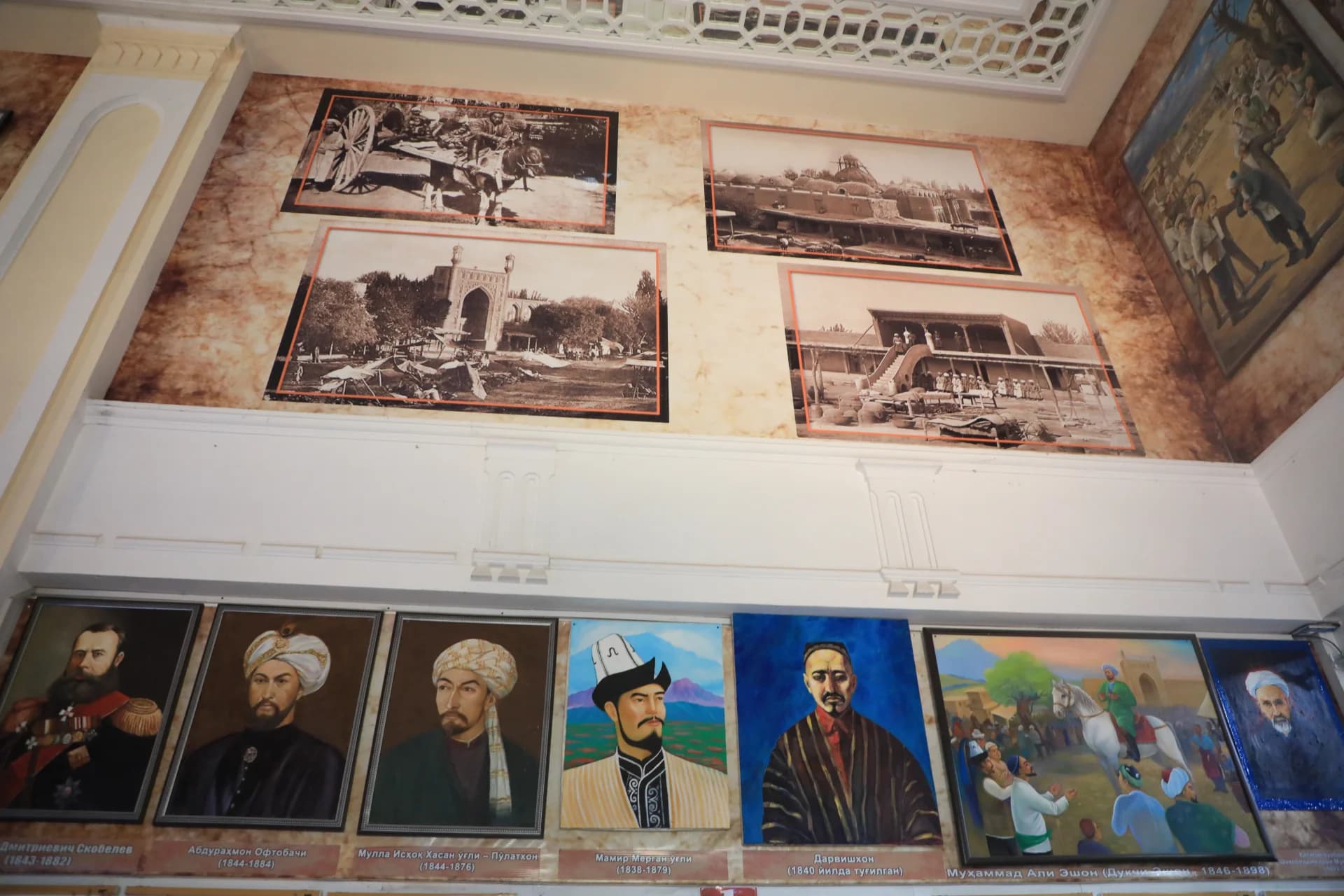 Historical photographs and paintings displayed on a museum wall