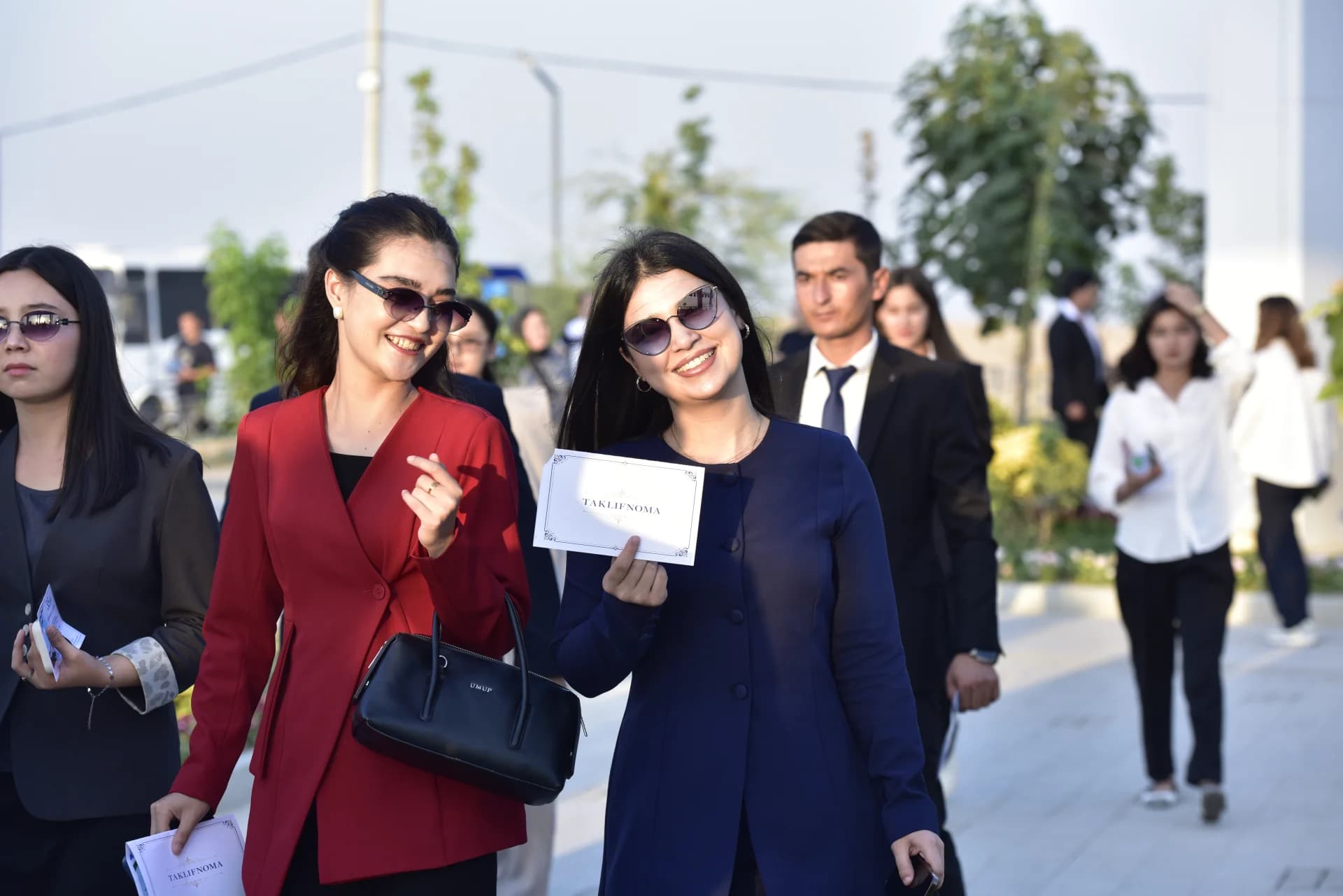 People gathered outdoors holding paper cards