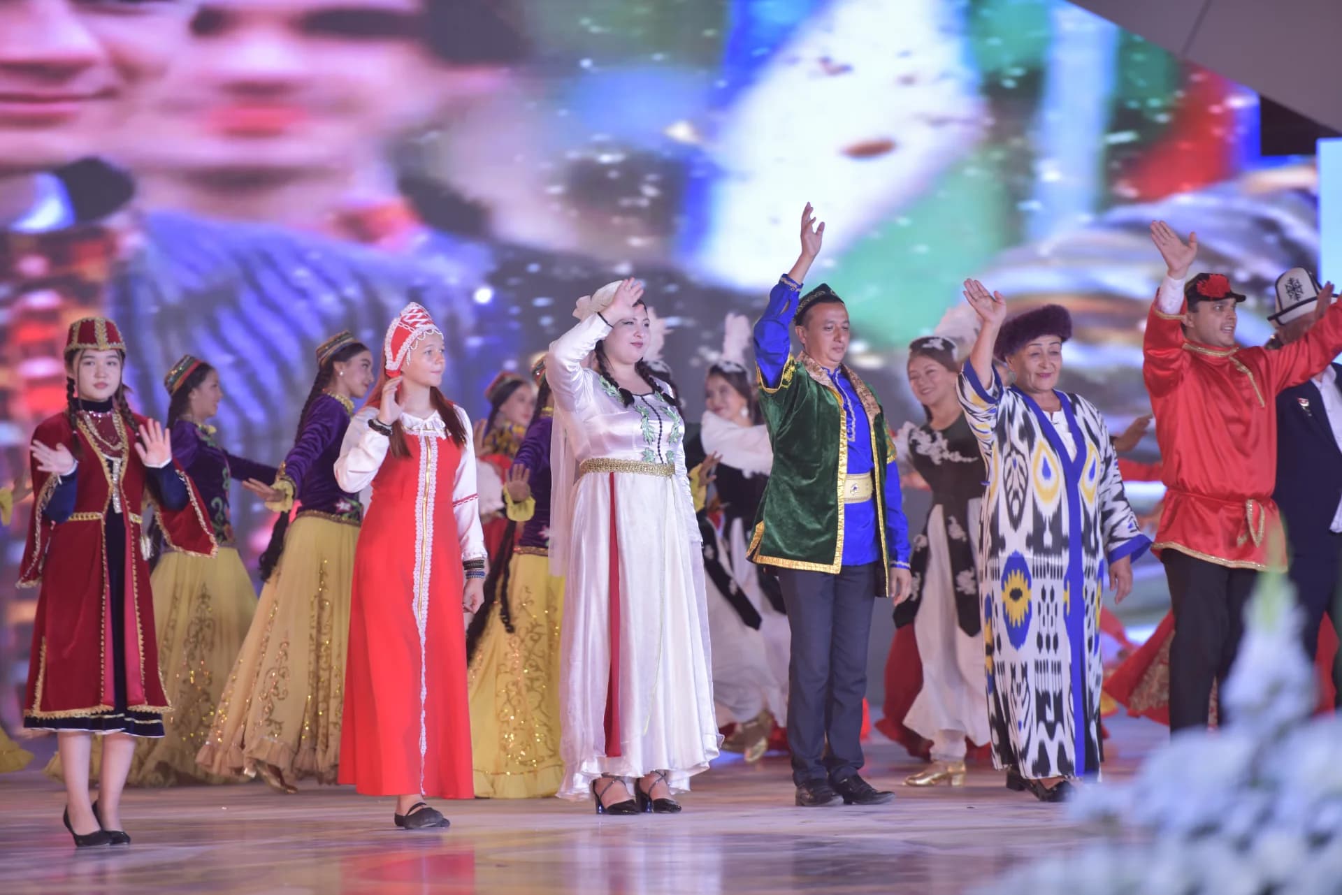 People in diverse national costumes perform on stage