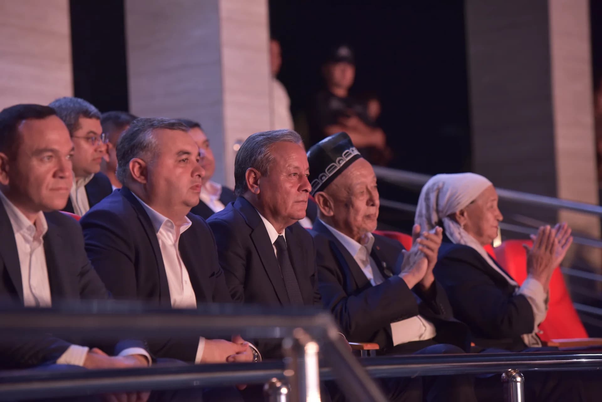 People sitting and clapping in an auditorium