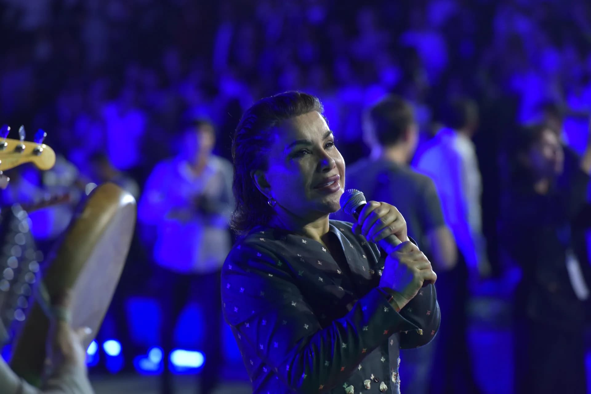 Person singing into a microphone on stage