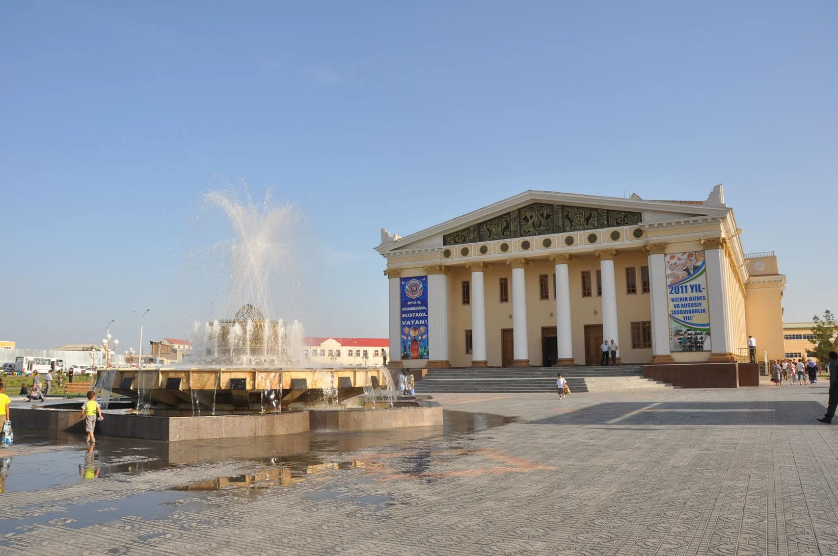 Фонтан перед классическим зданием на городской площади