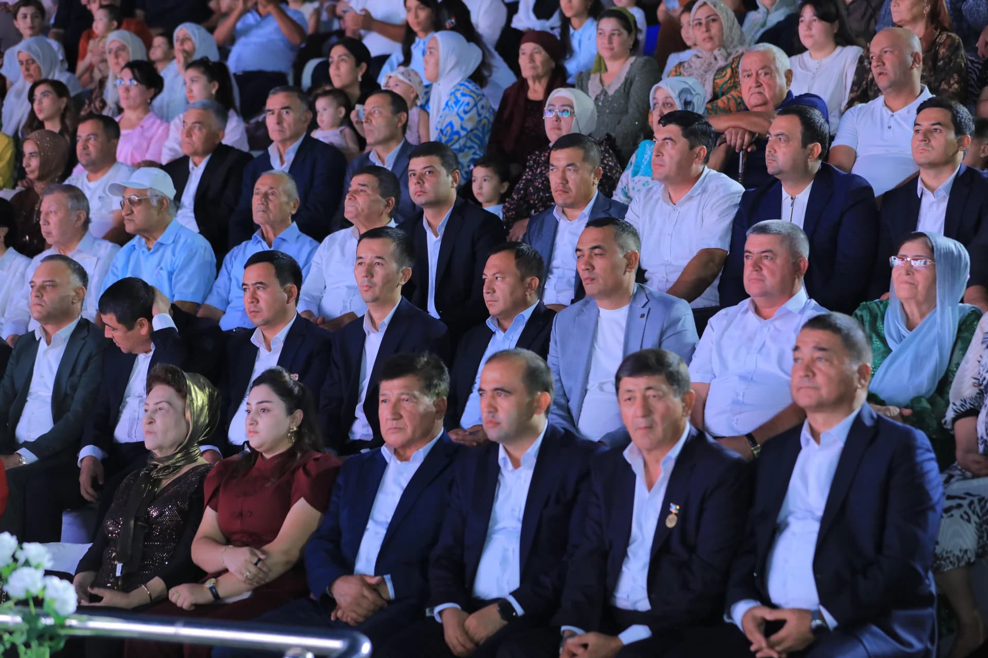 People seated in an audience watching a public event