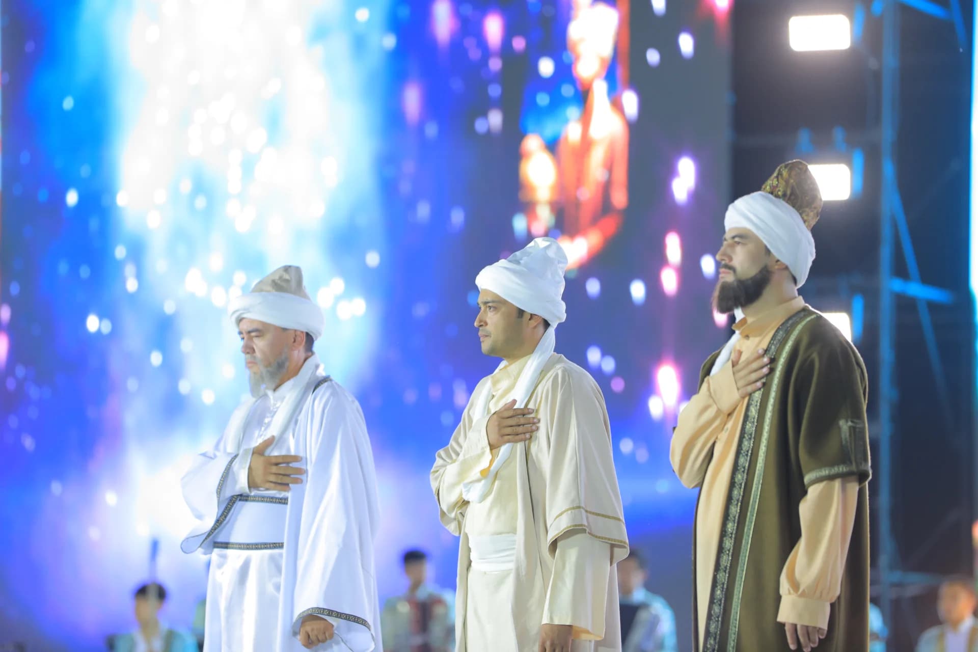 People in traditional clothing with hands on chests