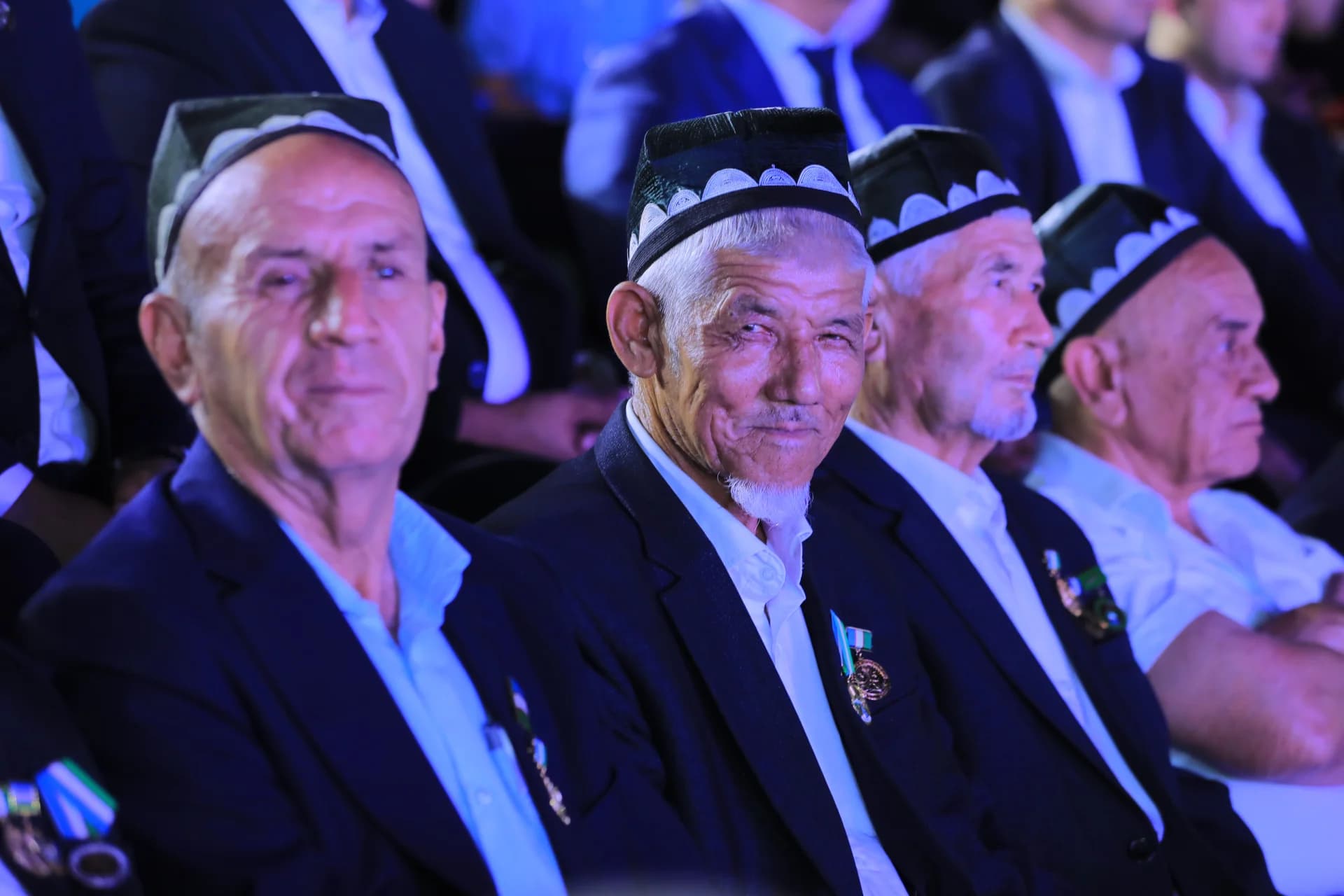 Seniors seated wearing traditional caps