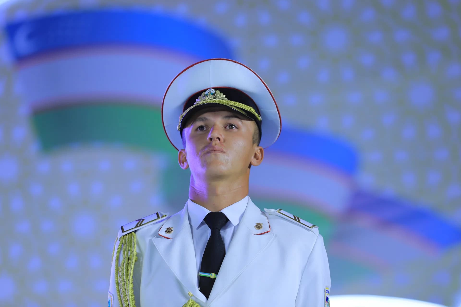 Person in military-style uniform with white cap and gold-trimmed epaulets