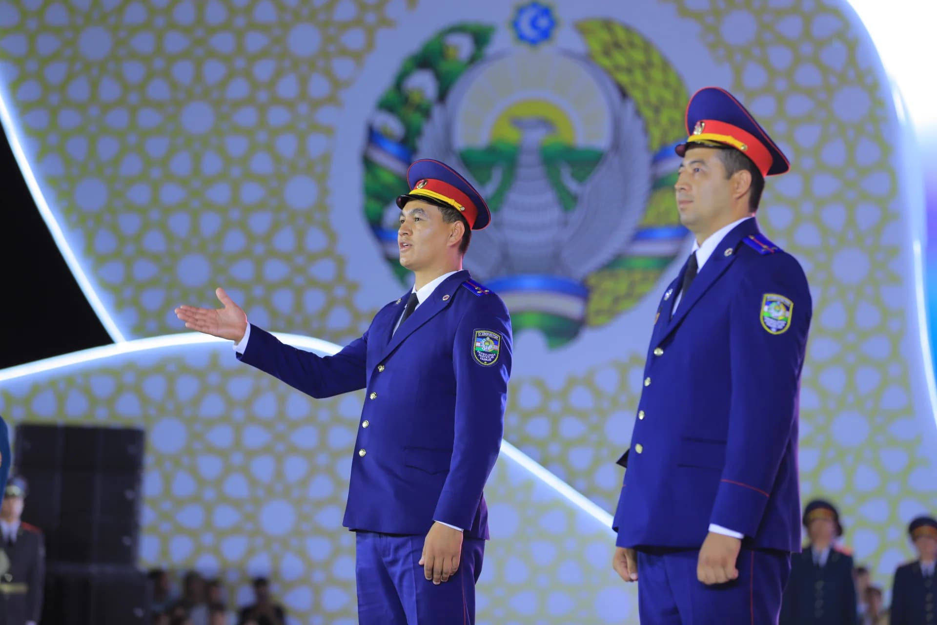 People in uniform stand on stage during an event